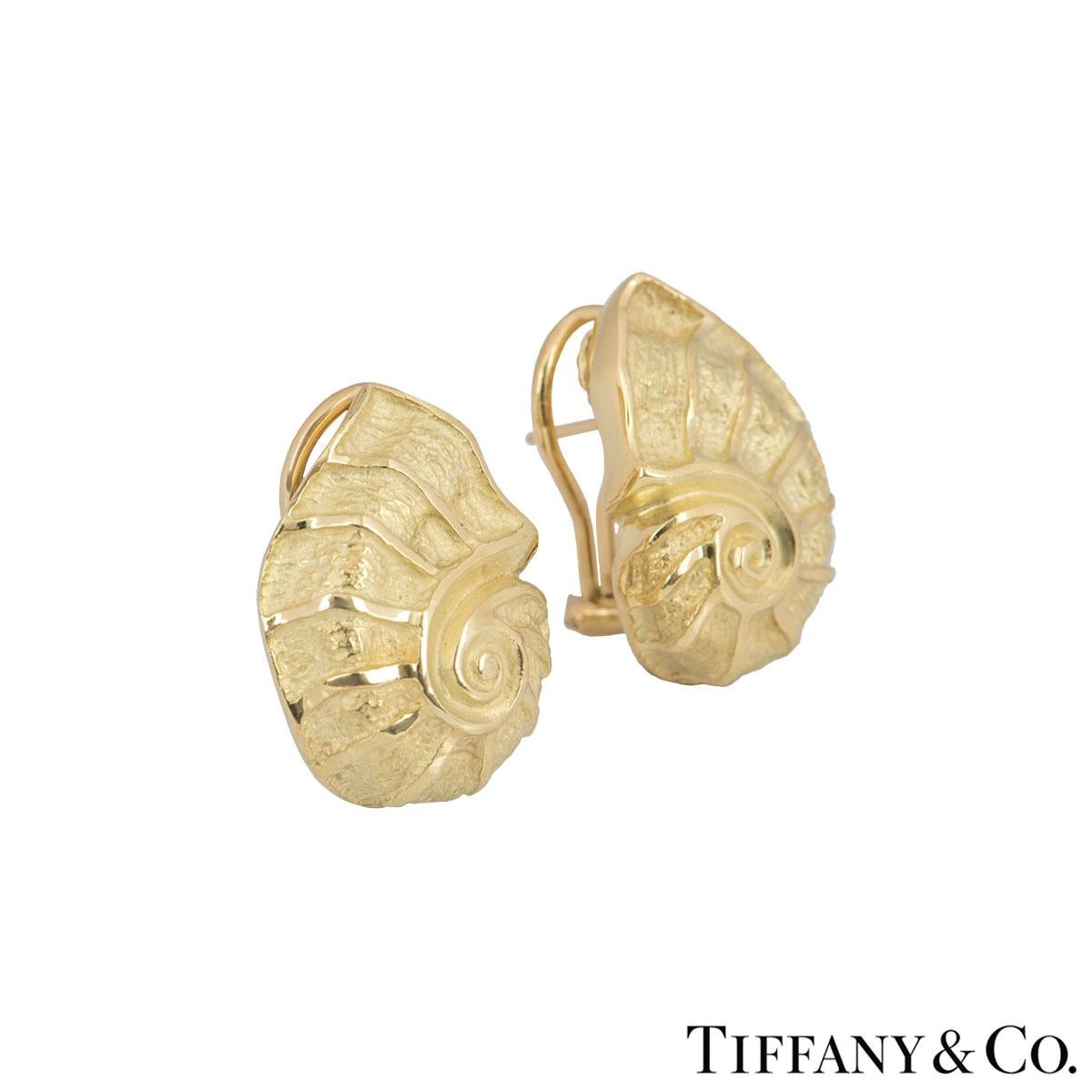 A pair of 18k yellow gold earrings by Tiffany & Co. The earrings are in a design of a nautilus shell in yellow gold. The earrings feature a post with lever-hinged fitting and measure 2.30cm in length, width of 1.60cm and a gross weight of 19.00