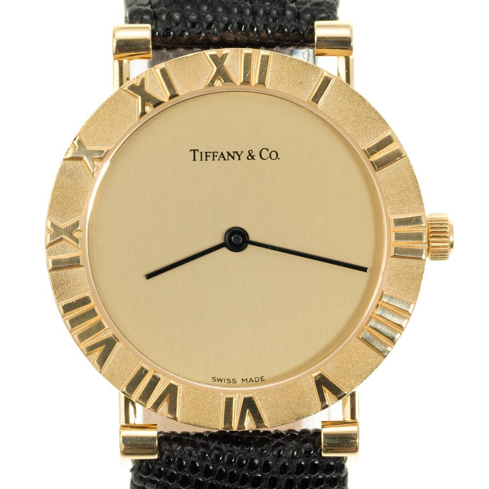 Men's or Ladies 32mm fully serviced Tiffany & Co Altas Quartz Wristwatch. 18k yellow gold bezel with Roman numerals. 

Length: 36.89mm
Width: 31.91mm
Band: 17mm
Crystal: sapphire
Dial: gold
Outside case: Tiffany & Co Atlas M0630 78-064 18k
Inside