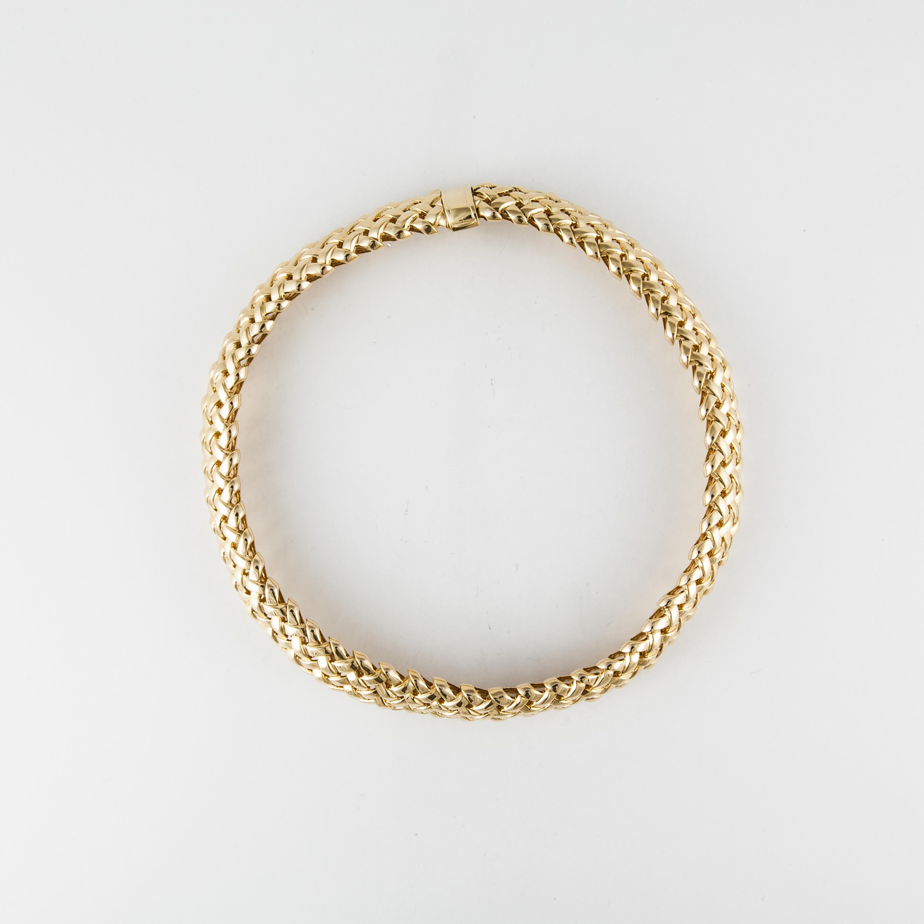  Woven necklace in 18K yellow gold.   Clasp is a fold over safety.  Measures 16