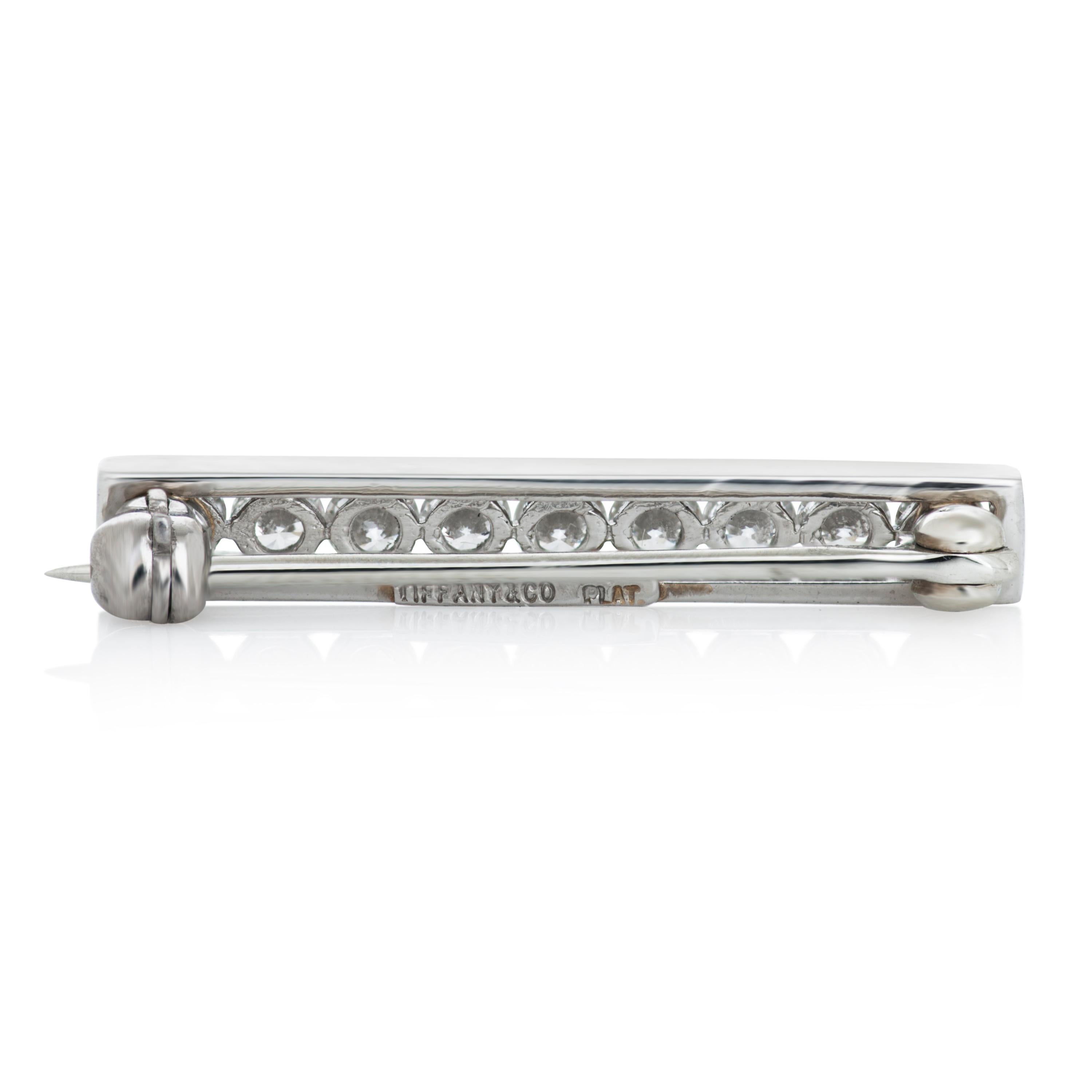 Tiffany & Company round diamond bar brooch in platinum.

This Tiffany brooch features 9 round brilliant cut diamonds totaling approximately 0.50 carat with E color and VS clarity. 

24.55mm long by 3.6mm wide.
2.6 grams.

Stamped 