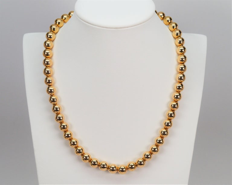A timeless classic from Tiffany & Company. Brightly polished fourteen karat 14K yellow gold 8.25 mm beads create this chic 18 inch necklace. Always in style and for all ages, this desirable gold beaded strand is finished with a lobster clasp and