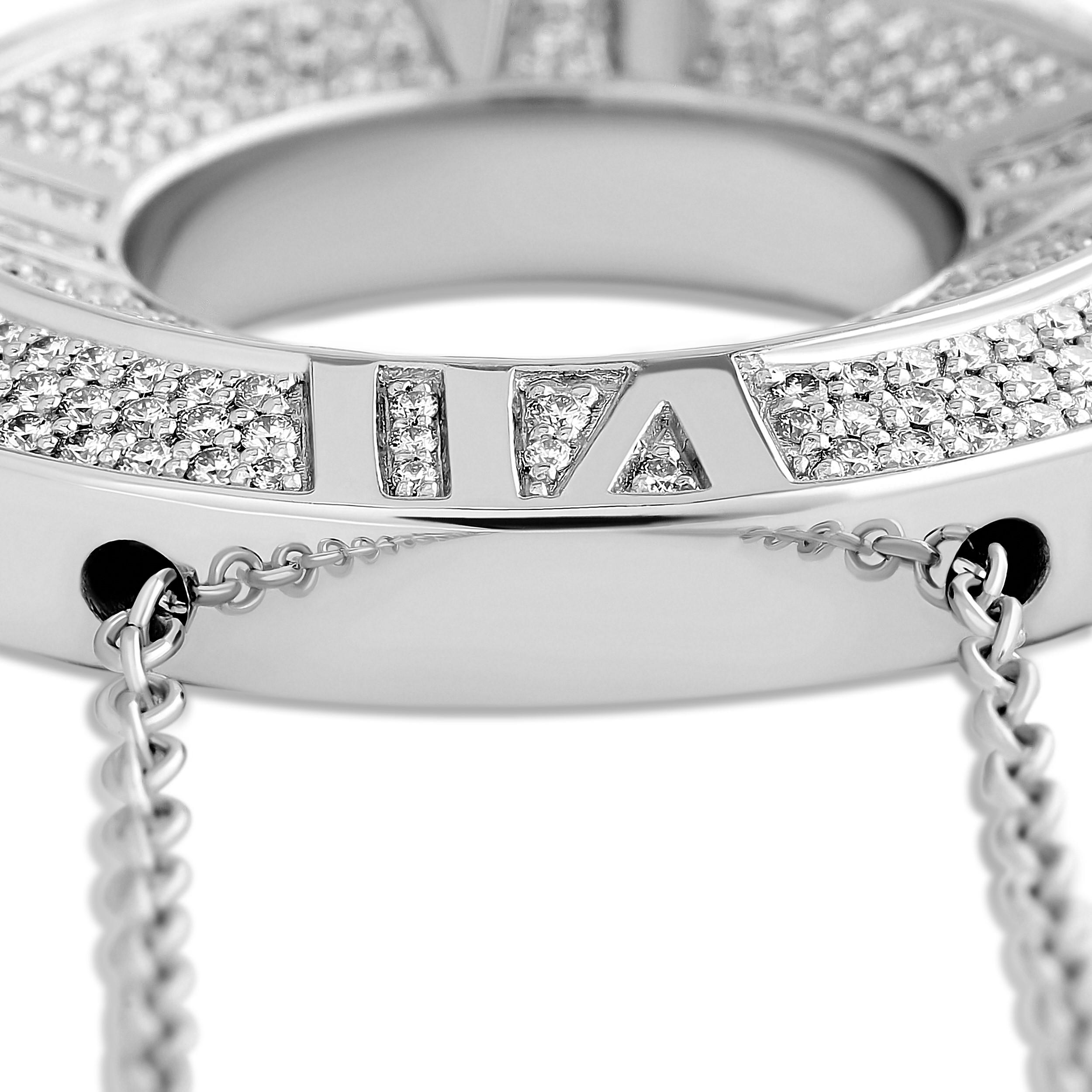 Questo raffinato ciondolo di Tiffany & Co. mostra l'iconico motivo dell'Atlante. Realizzato in oro bianco 18 carati, il ciondolo presenta un numero romano che simboleggia il tempo e l'eternità. L'aggiunta di diamanti scintillanti aggiunge un tocco