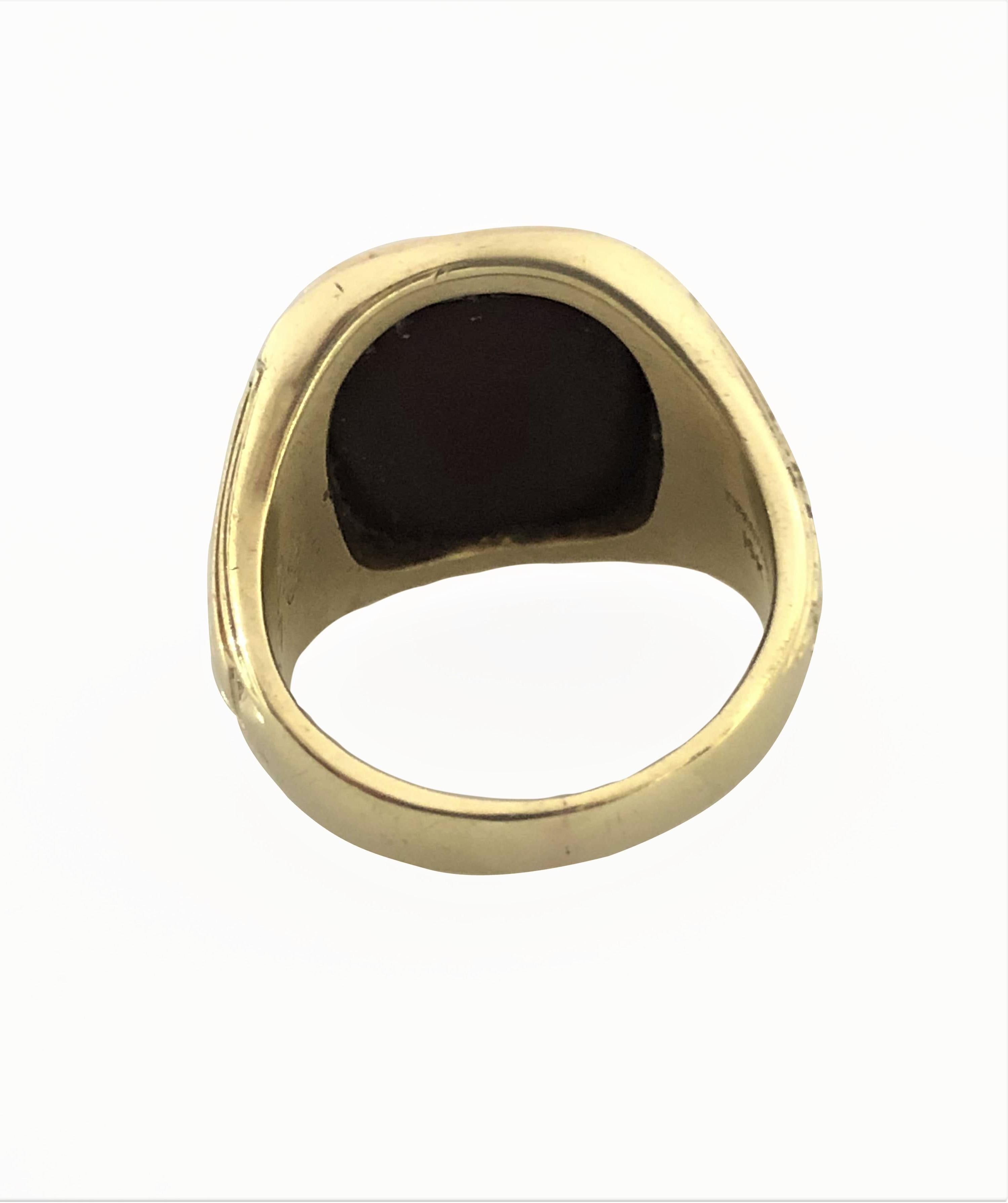 Circa 1910 Tiffany & Company  14k Yellow Gold Signet Ring, set with a dark Red-Brown Carnelian that is engraved with a Greek alphabet Omega symbol. The top of the ring measures 5/8 x 5/8 inch. Deep engraving on either sides of the ring. Finger size