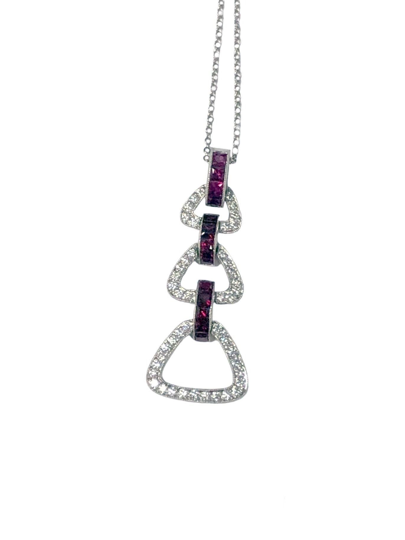 Collana con ciondolo in platino di Tiffany & Co. del 2000 circa. Il ciondolo, con ogni sezione attaccata e articolata singolarmente, misura 1,5 pollici di lunghezza ed è incastonato con diamanti rotondi taglio brillante e rubini quadrati taglio a