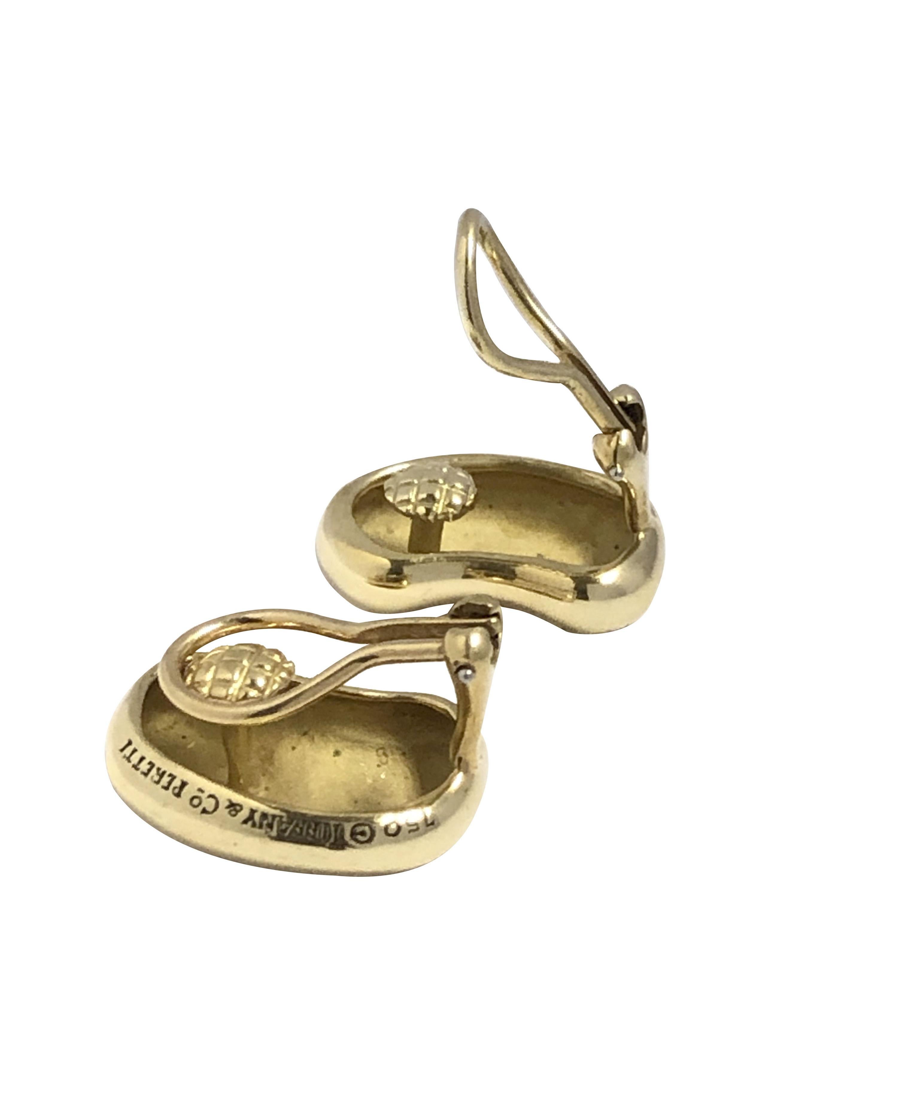 Circa 1990 Elsa Peretti for Tiffany & Company 18K Yellow Gold Classic Bean Earrings, measuring 3/4 inch in length and 1/2 inch wide and weighing 17.2 grams. Omega clip backs  to which a post can be added if desired.Comes in original Tiffany