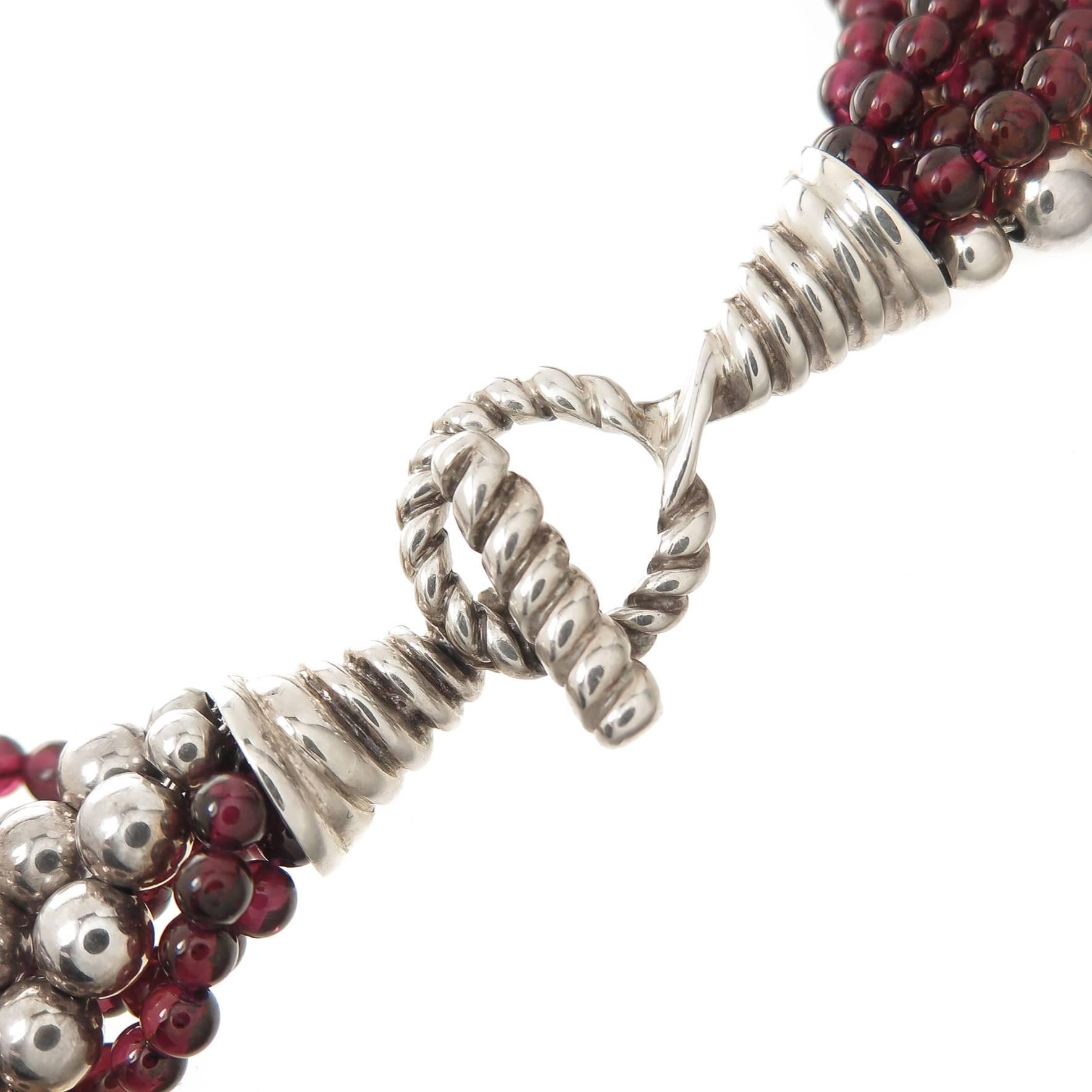 Circa 1990s Tiffany & Company Torsade Necklace, comprised of 5 strands of 4 M.M. Round Garnet and 2 Strands of 6 M.M. Sterling Silver Beads, measuring 16 1/2 Inches in length and 1 inch wide. Having a toggle clasp. Comes in original Tiffany Box.