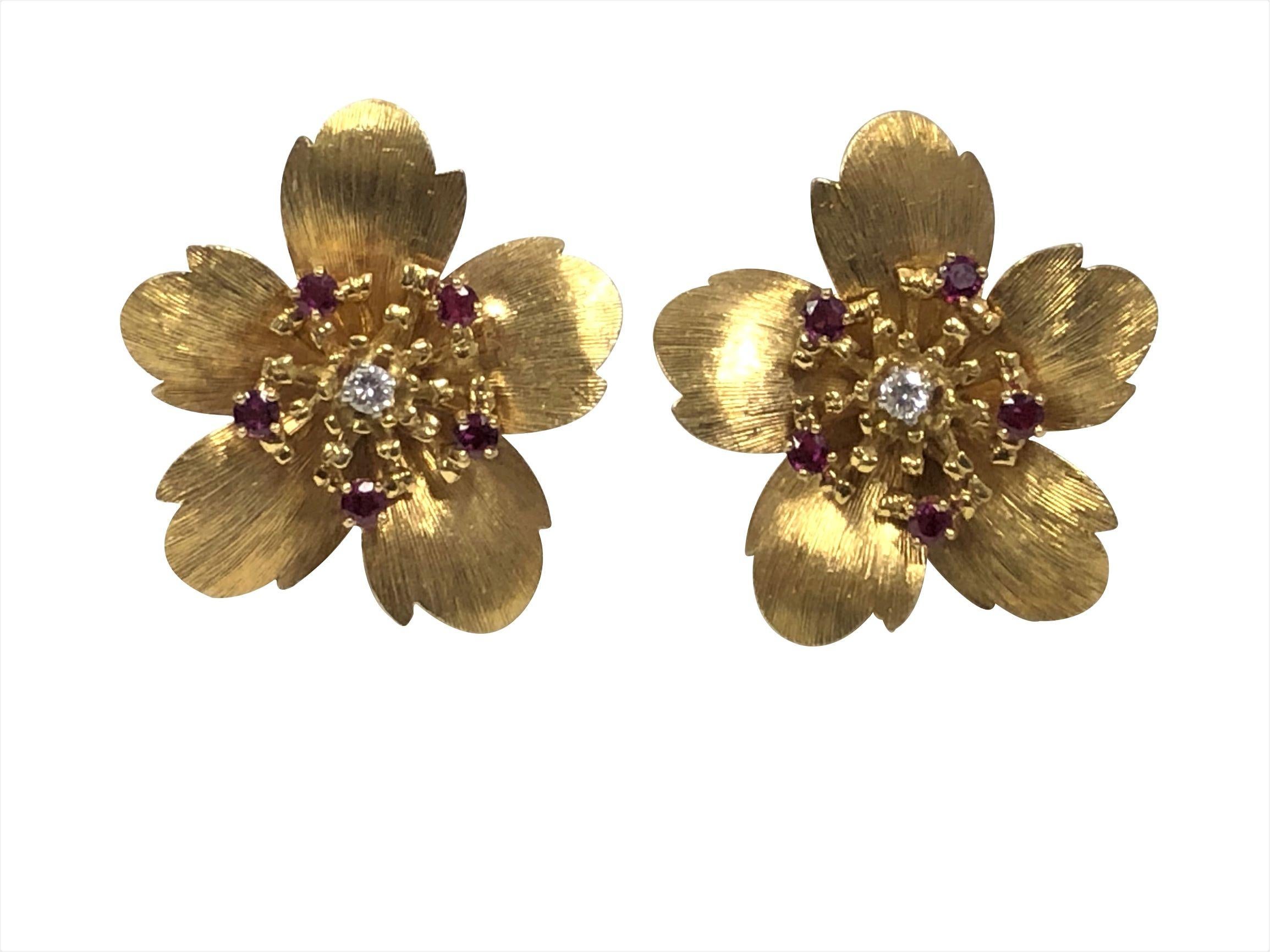 Circa 1980 Tiffany & Company Flower Earrings, measuring 1 1/4 inch in diameter, having textured Pedals and set with a Round Brilliant cut Diamond in the center and surrounded by Rubies. Clip Backs, weighing 21.5 Grams and come in the original