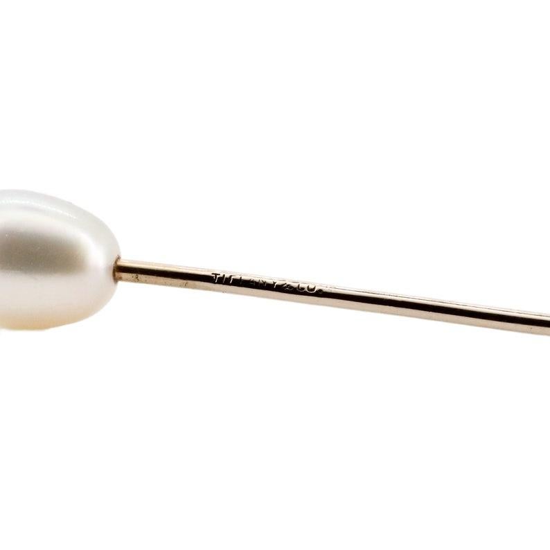 A rare natural pearl stick pin by Tiffany & Company. Set with a single natural saltwater pearl of beautiful iridescent white color. The pearl measuring 10mm in length by 7.5mm in width, and being mounted on a plain high polished stick pin.

Signed