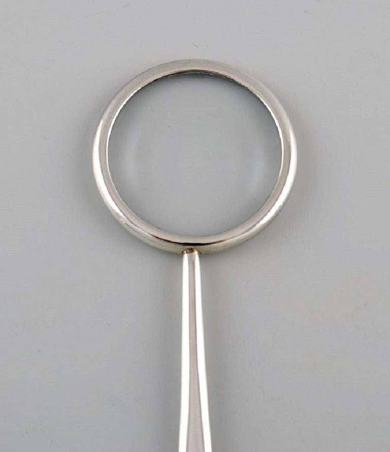 Tiffany & Company, New York. Magnifying glass in sterling silver. 1980s. 
Designed by Elsa Peretti.
Measure: Length: 11.7 cm.
In excellent condition.
Stamped.
Our skilled Georg Jensen silversmith can polish all silver and gold so that it