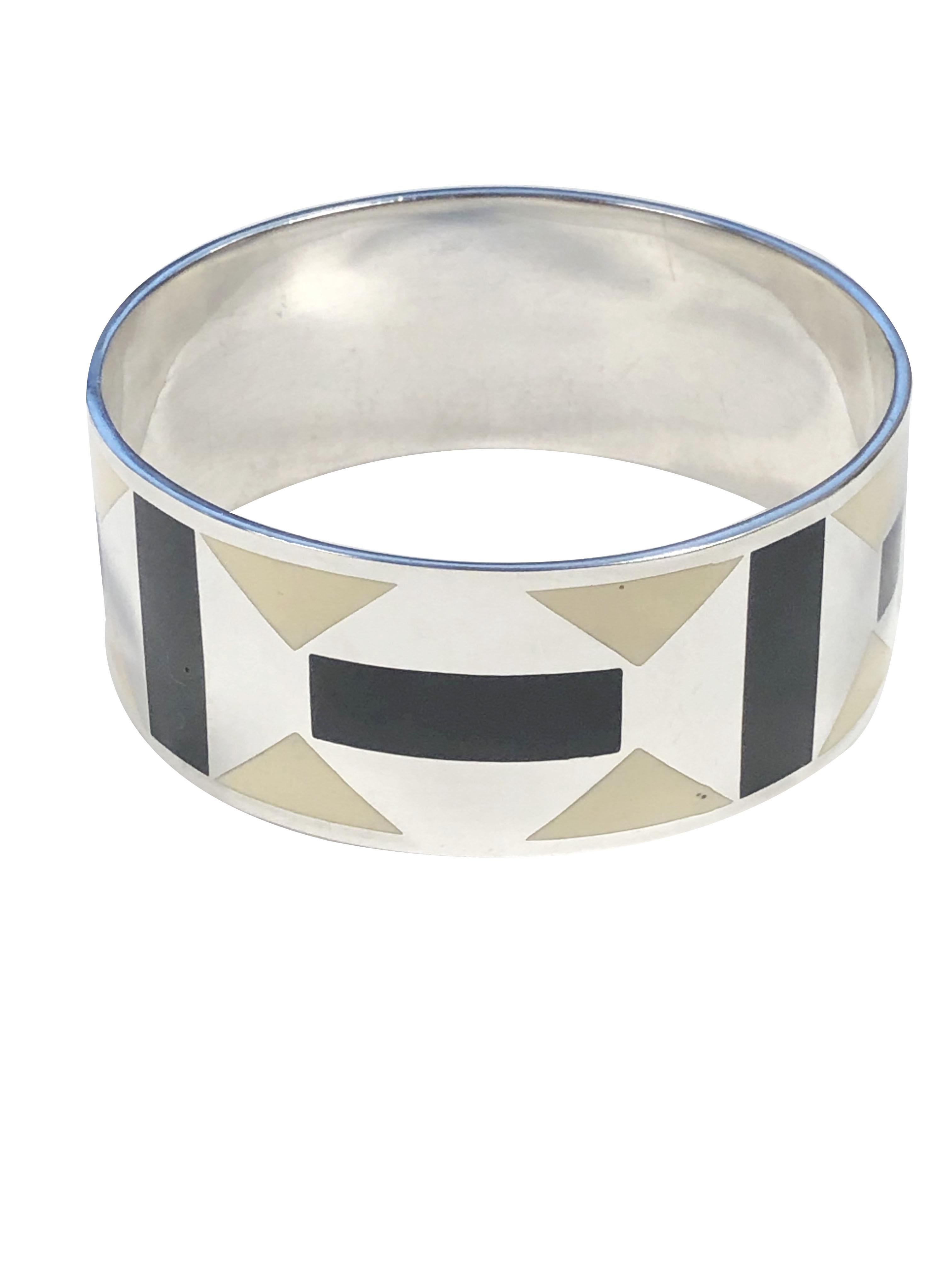 Circa 1990s Paloma Picasso for Tiffany & Company Zellige collection Sterling Silver Bangle Bracelet, measuring just over 1 inch wide and having an alternating Art Deco style pattern in Ivory and Black Enamel. Inside measurement 7 1/2 inches. Comes