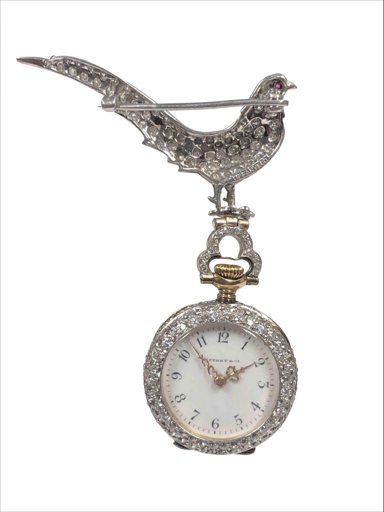 Circa 1910 Tiffany & Company Magnificent and all original Bird Form Lapel Pin and Pendant Watch, The signed Tiffany Platinum Cased watch measures 24 M.M. and is set with White Clean Old Mine cut Diamonds. Signed Tiffany & Company, Jeweled Nickle