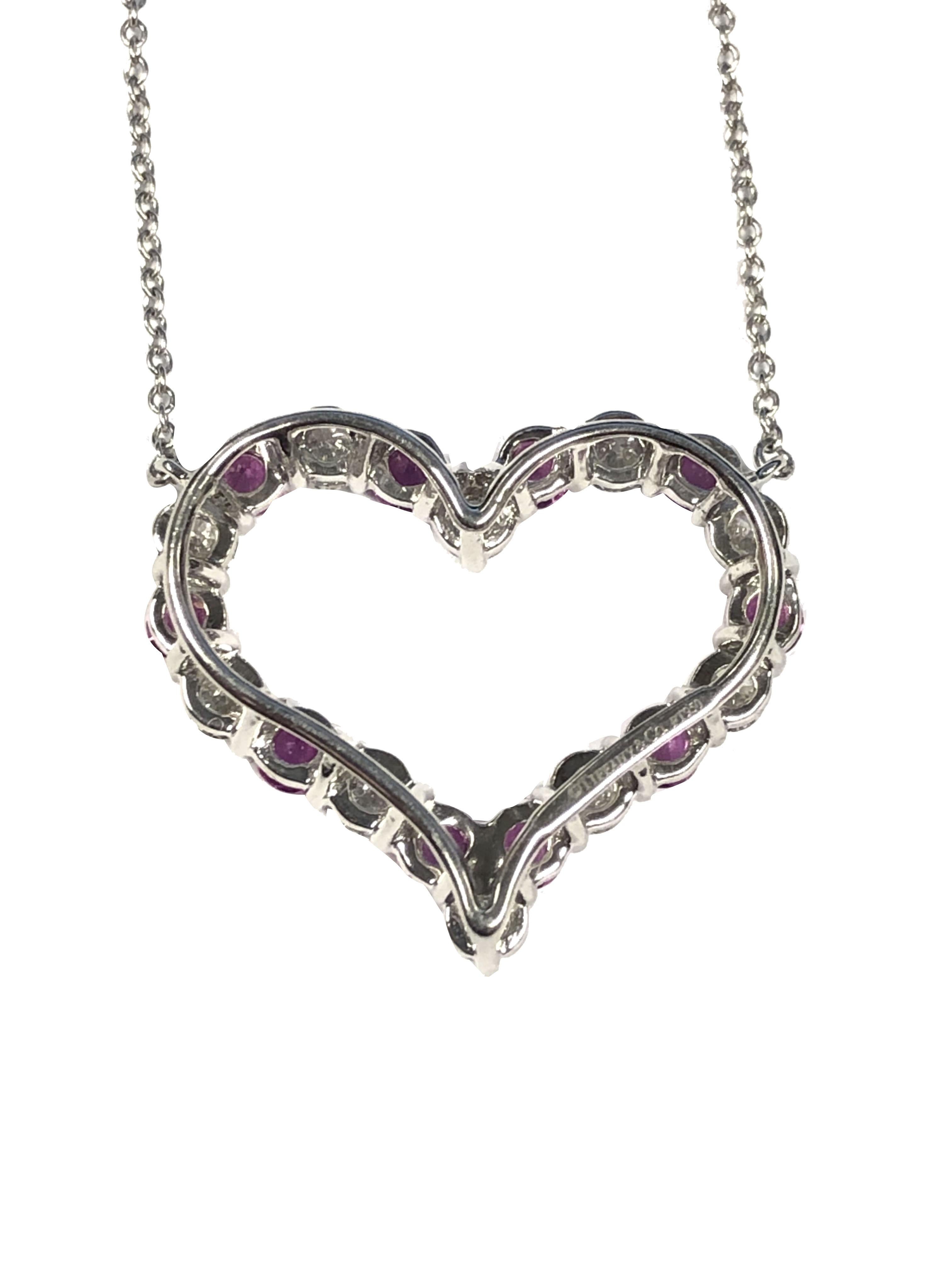 Circa: 2018 Tiffany & Company Platinum Open Heart Pendant Necklace, the Heart measures 1 X 7/8 inch and is set with Round Brilliant cut Diamonds totaling 1 Carat and grading as G in color and VS clarity, further set with Round Pink Sapphires of very