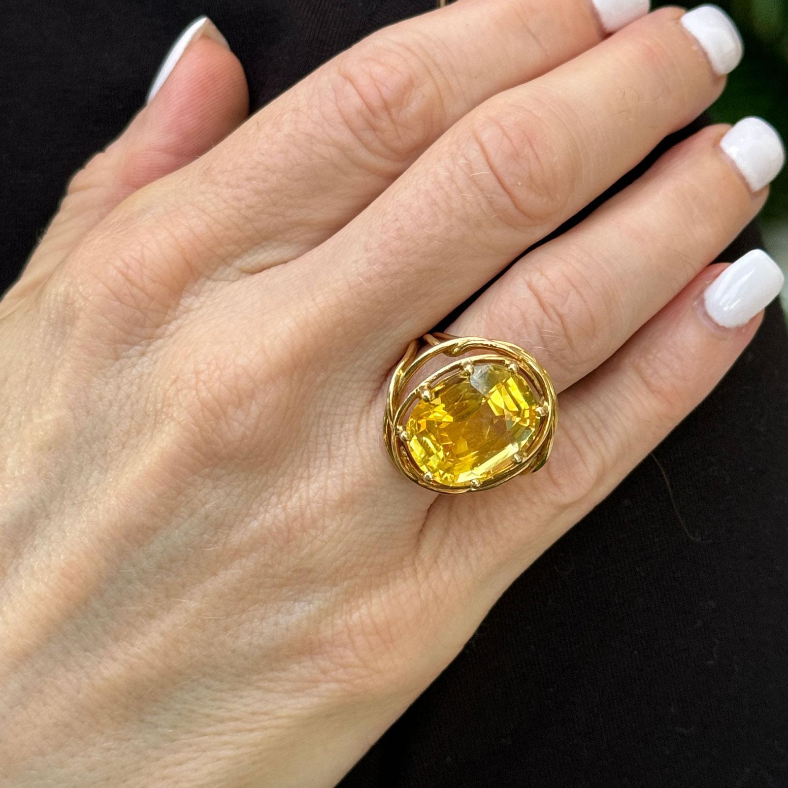 This exceptional Tiffany & Co. Jean Schlumberger ring features a rare, GIA-certified, no-heat yellow sapphire weighing an impressive 16.13 carats. The oval-cut sapphire, with its vibrant, sunny hue, measures approximately 20 x 25 mm across the top,