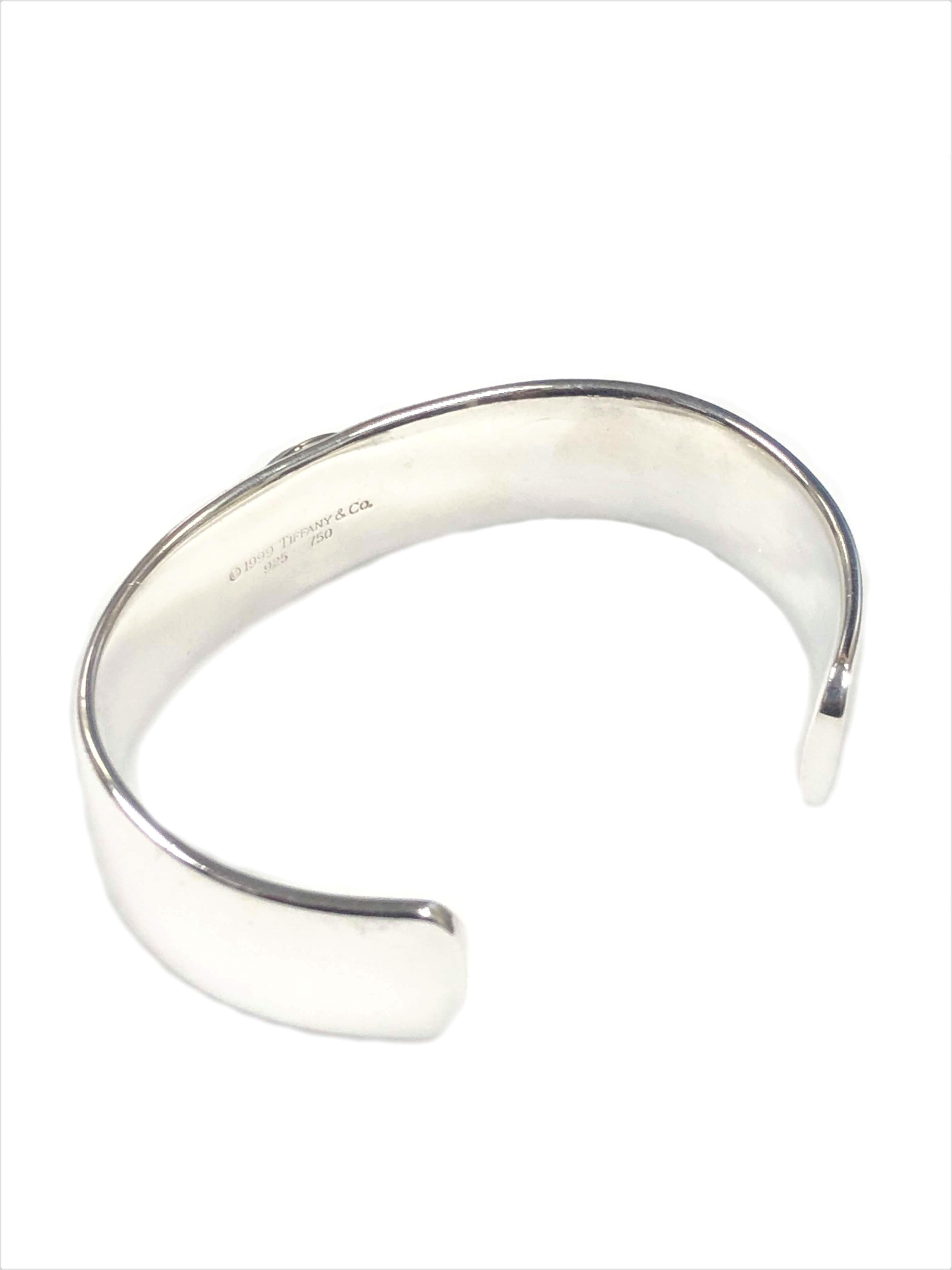 Circa 1999 Tiffany & Company Sterling Silver Cuff Bracelet, formed from very thick gauge Silver, measuring 5/8 inch wide and 3 MM thick. Centrally set with a Hematite stone in an 18K Yellow Gold bezel. Wrist size 6 inches with a 1 1/4 inch opening