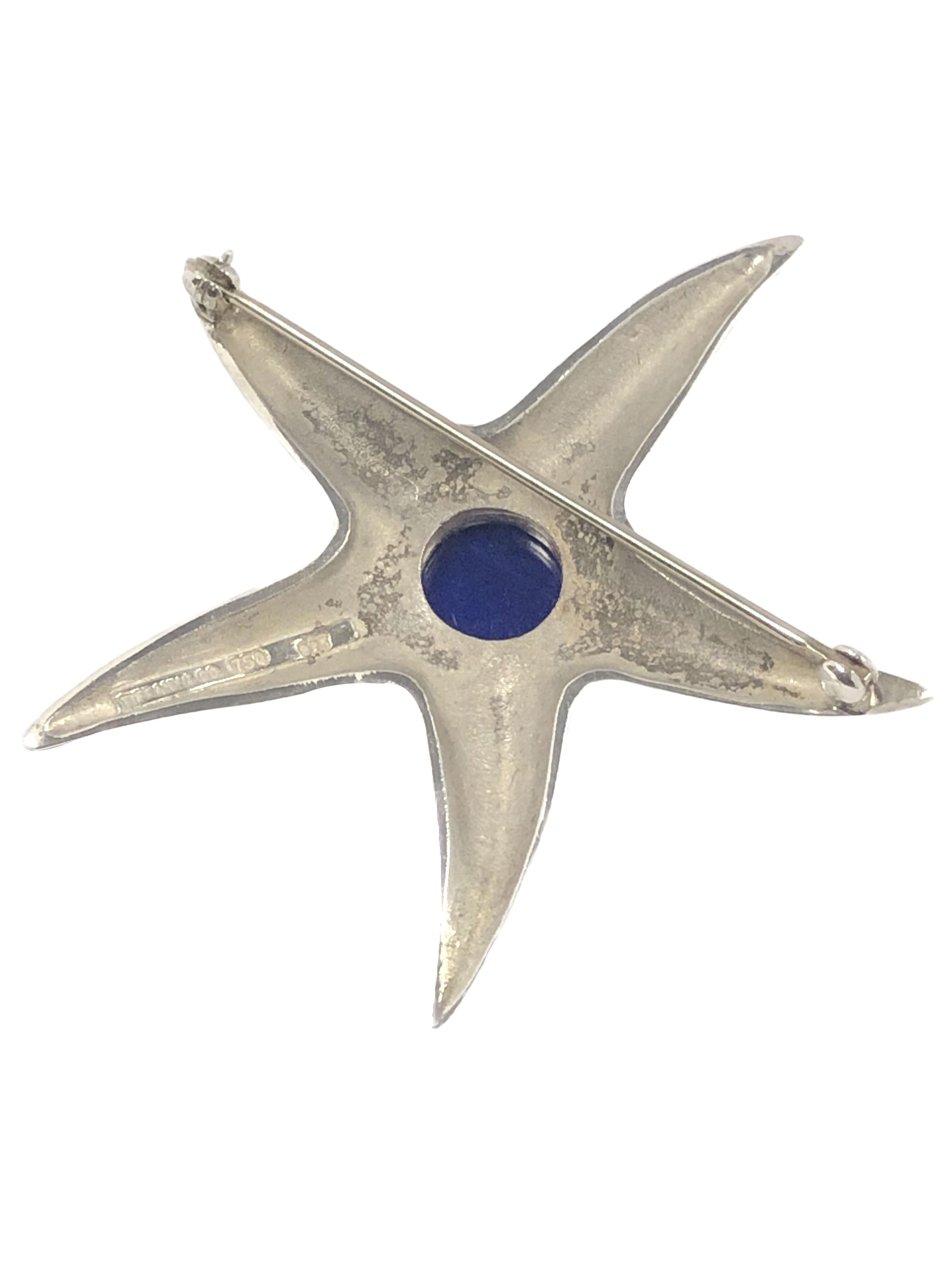 Circa 1990 Tiffany & Company Sterling Silver Starfish Brooch, measuring 2 inches in diameter, an 18k Yellow Gold bezel set with a Lapis Lazuli. Comes in original Gift Box.