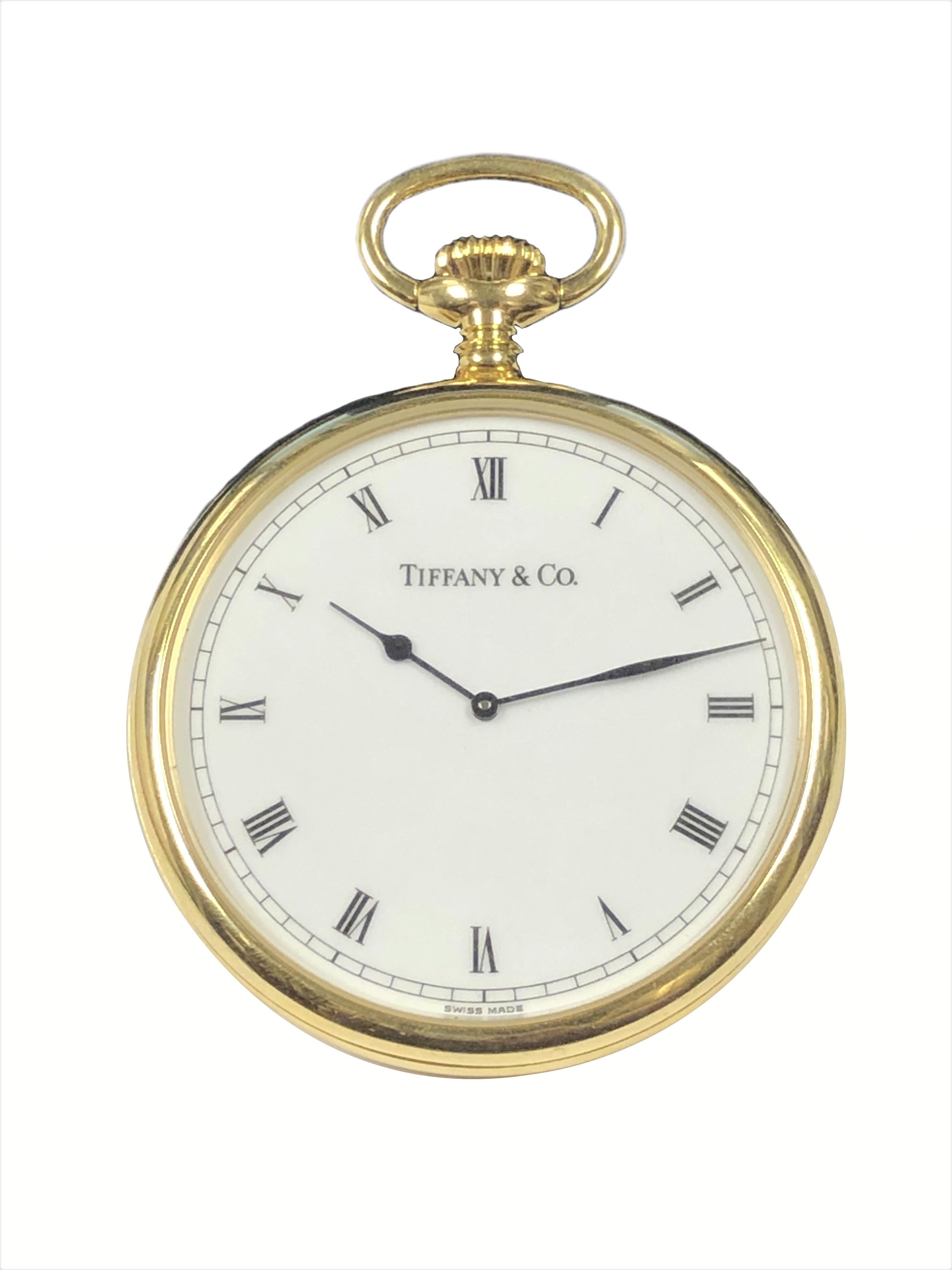 Circa 1990s Tiffany & Company presentation Pocket Watch, 49 M.M. X 7 M.M. thick 18K Yellow Gold 3 piece case, quartz Movement, White Dial with Black Roman Numerals, the back of the watch is specially custom engraved with the Crest of Cambridge