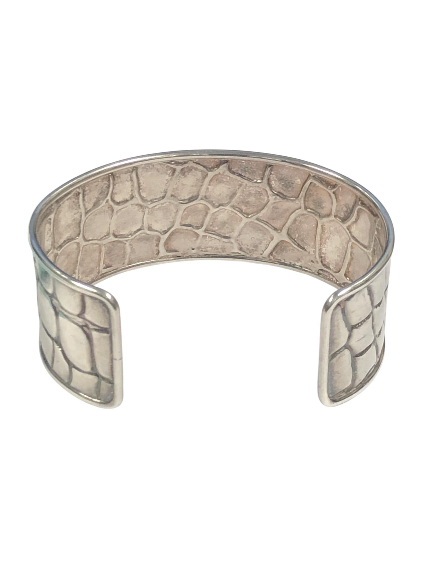 Circa 1990 Tiffany & Company Sterling Silver Alligator Texture Cuff Bracelet, mesurant 1 pouce de large avec une mesure intérieure de 5 1/2 pouces et une ouverture de 1 1/2 pouces, taille du poignet 7 pouces et est réglable.