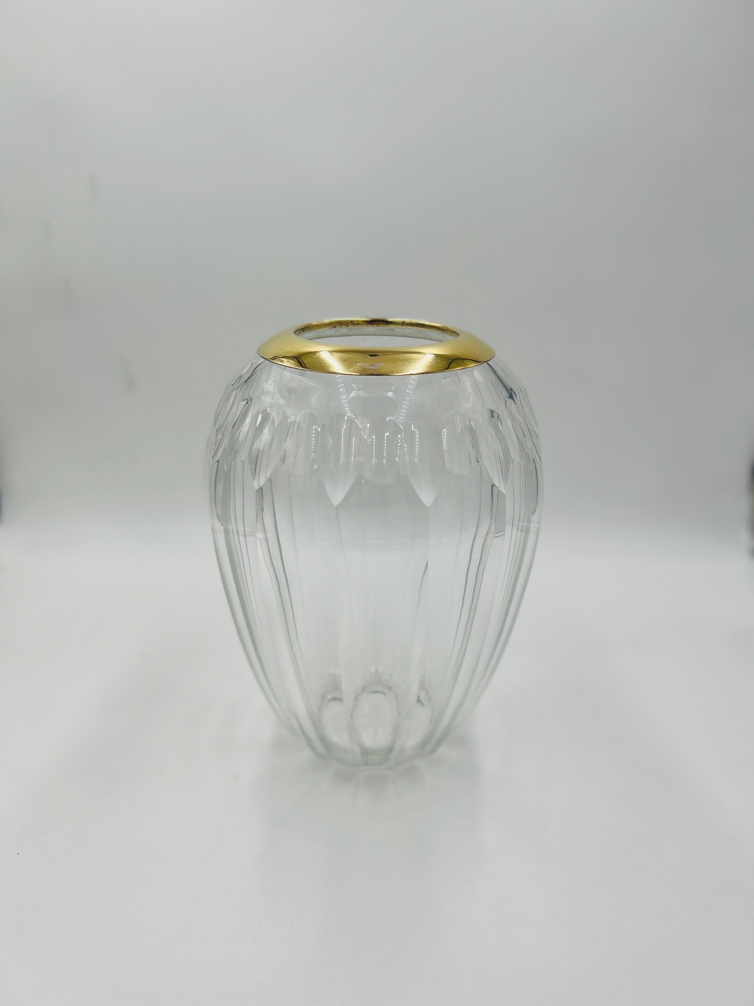 A Tiffany & Company gold over sterling silver banded crystal vase. The vase made of German cut crystal with faceting to main body. Marked “Sterling, Germany, Tiffany & Company”. Vase itself is unmarked.