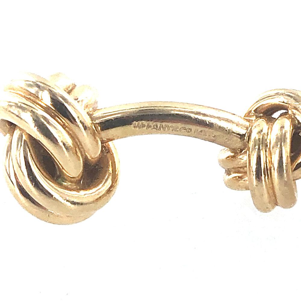 Timeless Tiffany & Company double knot cufflinks fashioned in 14 karat yellow gold. These vintage cufflinks are in great condition,  measure 12 x 28mm,  and are signed Tiffany & Co. 14k. Tiffany pouch included. 