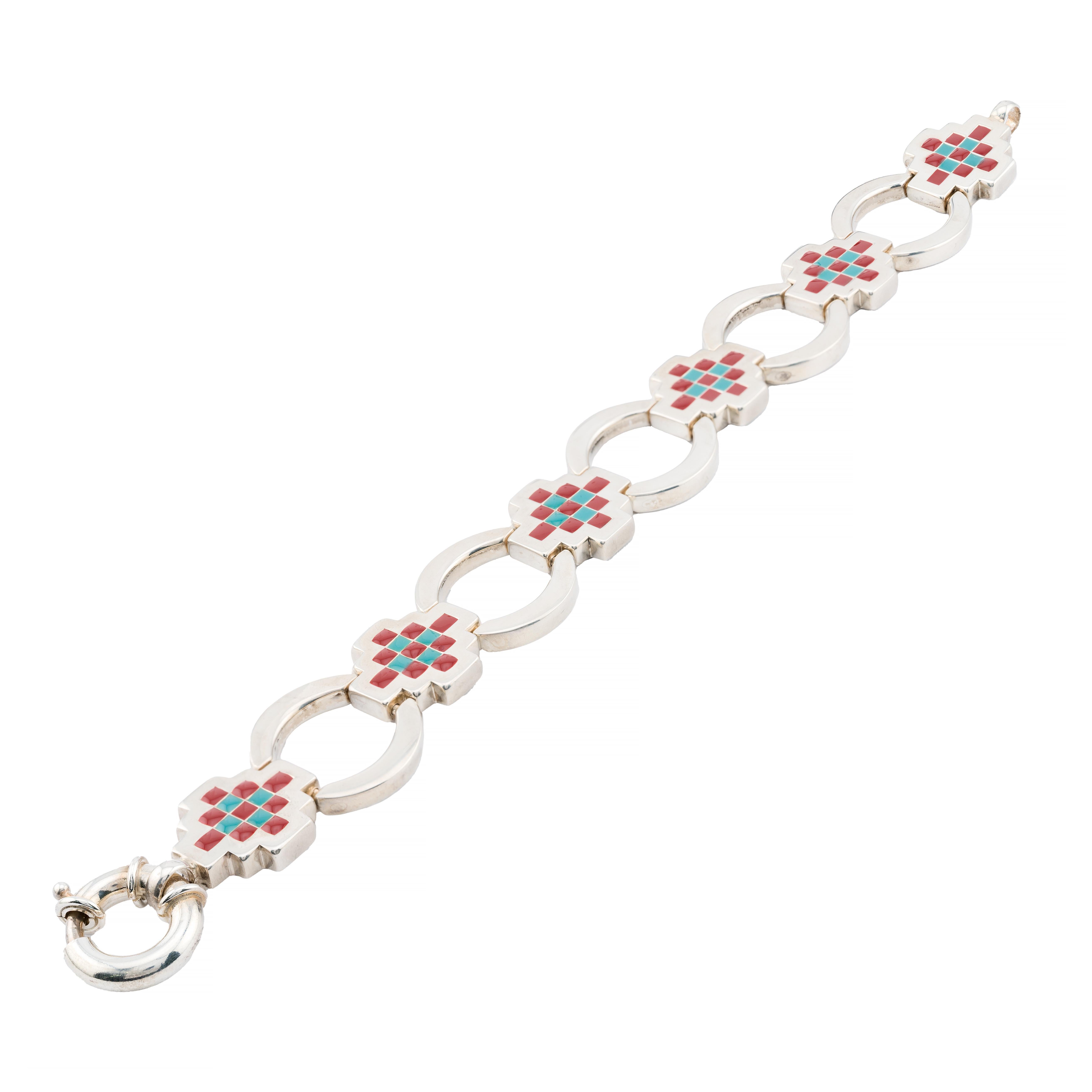 Aston Estate Jewelry Presents:

A Tiffany & Company sterling silver link bracelet featuring intricate geometric designs. Each link showcases a cross pattern with vibrant red and blue ename. The bracelet is composed of alternating circular and