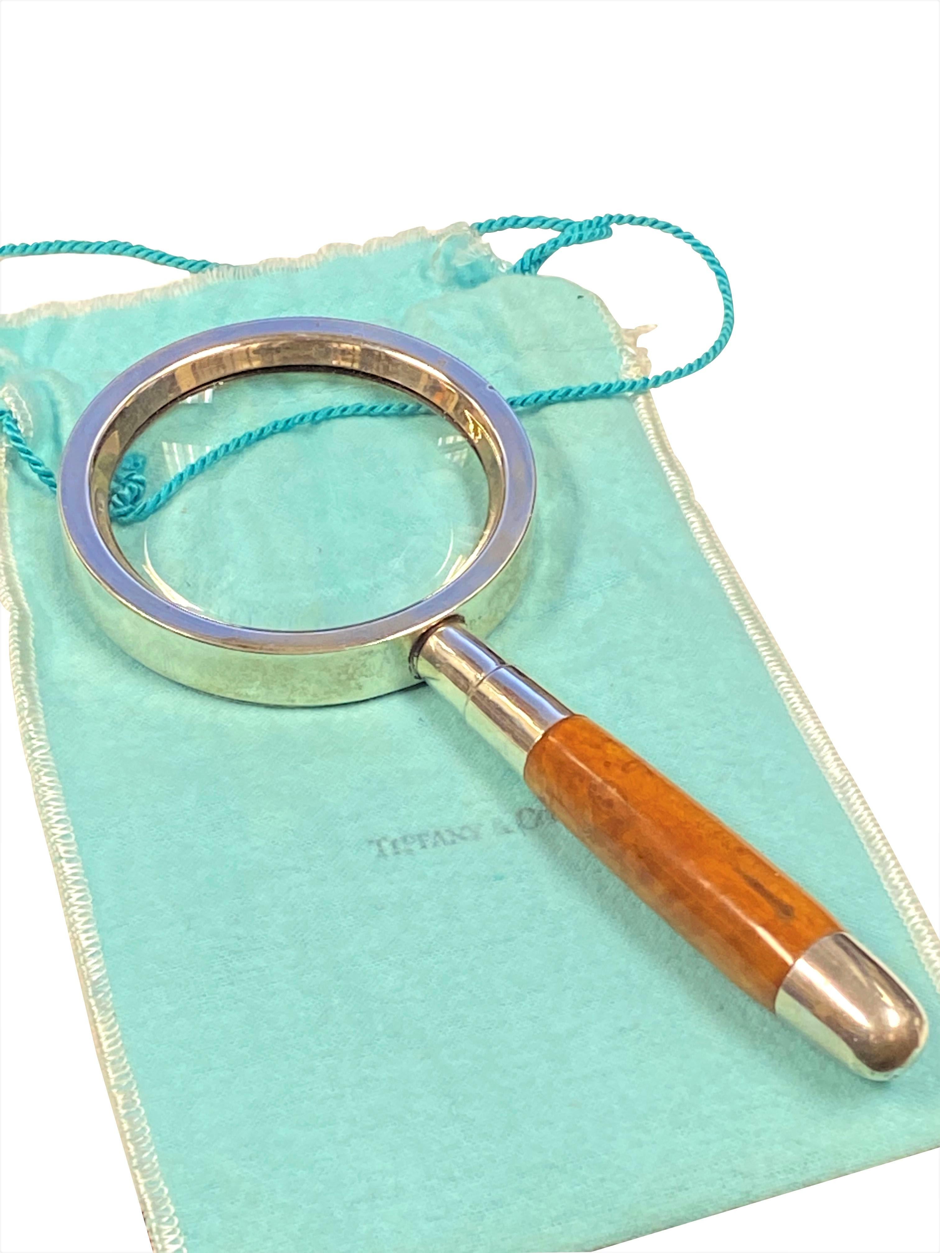Circa 1980 Tiffany & Company Magnifying Glass, A sterling silver capped Wood Handle and a Sterling Frame around the Glass, measuring 7 1/2 inches in length. In original Tiffany dust pouch.