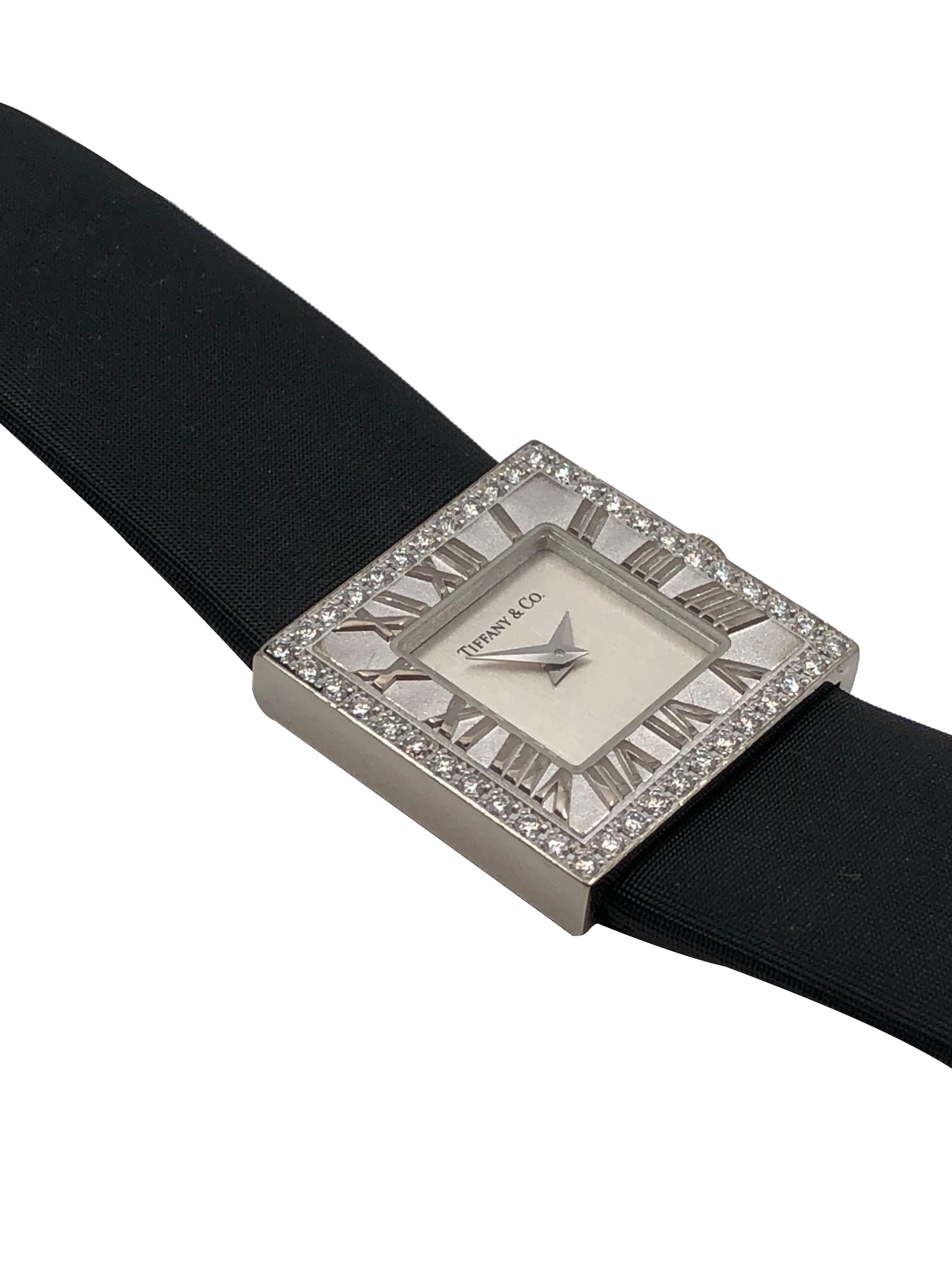 Circa 2005 Tiffany & Company 18K White Gold Atlas Collection Wrist Watch, 21 X 21 MM Water Resistant case, Quartz Movement. Silvered Dial. Raised Roman Numerals inner Bezel and outer bezel of round Brilliant cut Diamonds totaling approximately 1