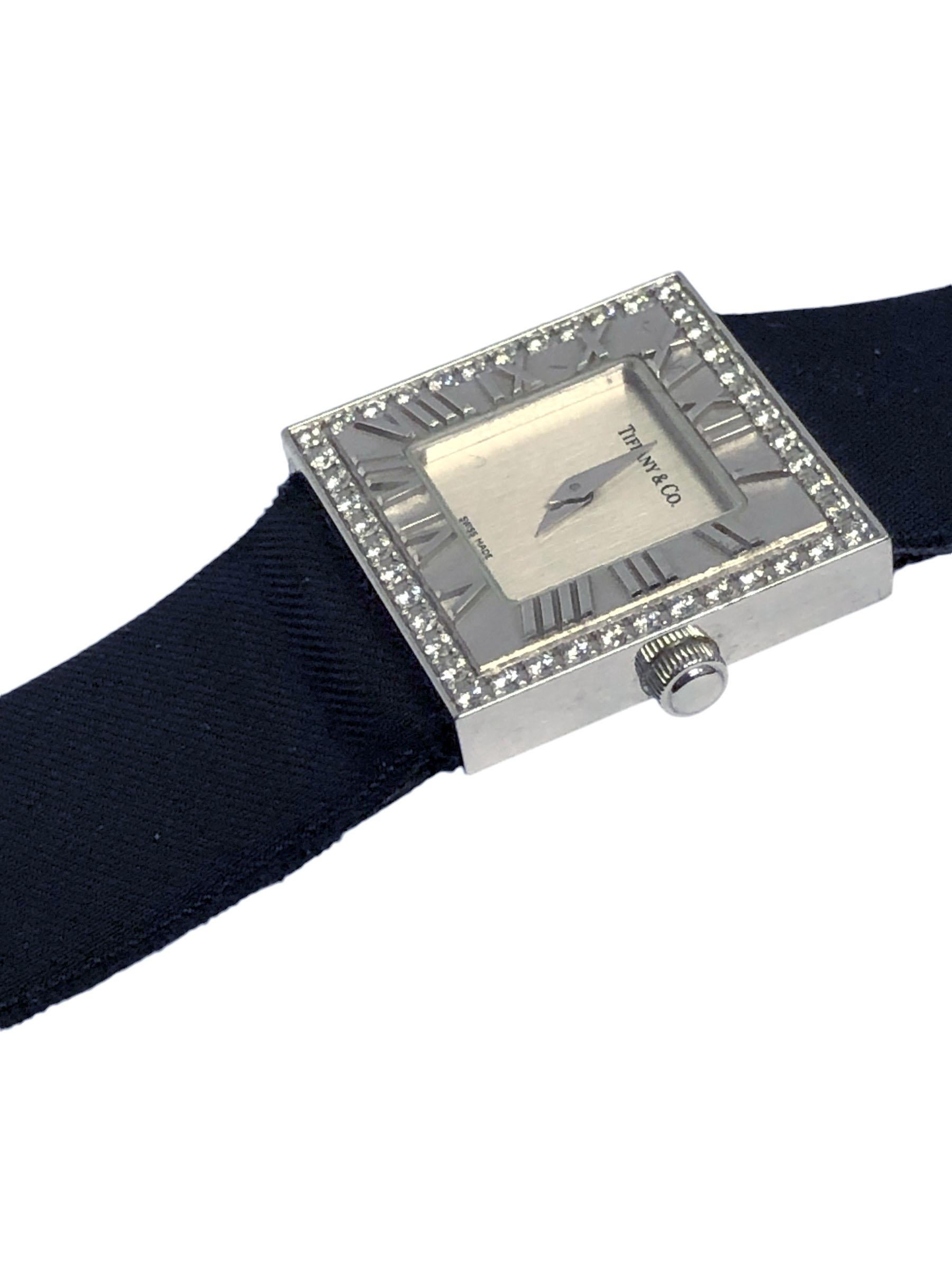Circa 2010 Tiffany & Company 18K White Gold Atlas Collection Wrist Watch, 21 X 21 MM Water Resistant case, Quartz Movement. Silvered Dial. Raised Roman Numerals on Bezel surrounded by Round Brilliant cut Diamonds totaling approximately 1 Carat.