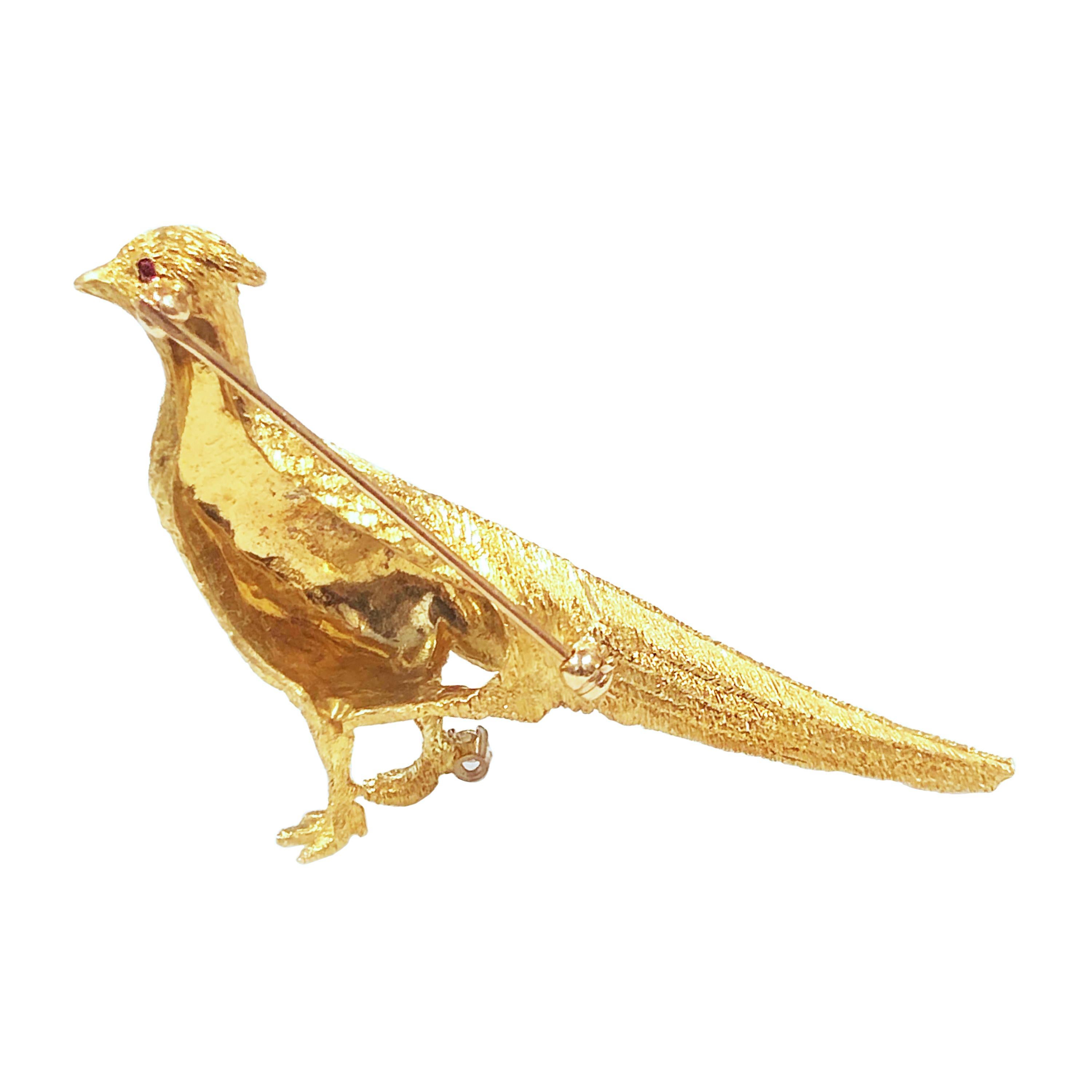 Circa 1980 Tiffany & Company 18K yellow Gold Pheasant Bird Brooch, measuring 2 1/2 inches in length X 1 inch and weighing 16.8 Grams. Hand finished with a Detailed textured Finish. Set with a Ruby Eye and a Diamond at the Foot. Comes in a Tiffany