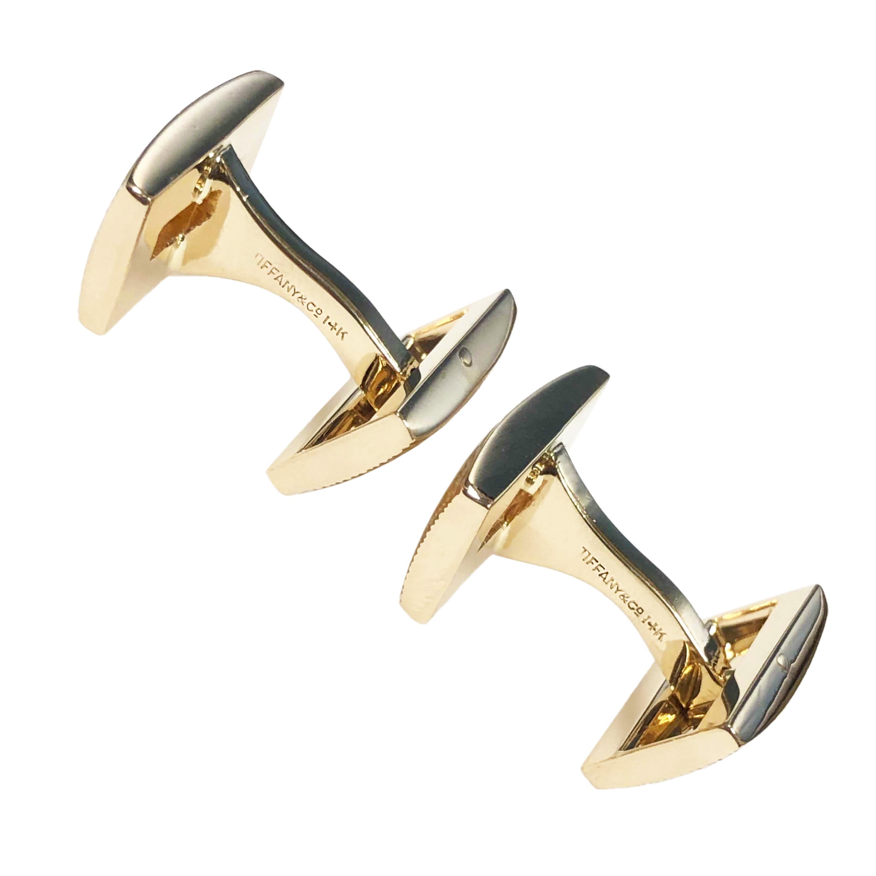 Circa 1990 Tiffany & Company 14K Yellow Gold Cufflinks, having a textured finish and centrally set with Square Step cut Diamonds totaling .75 Carat. The tops of the cufflinks measure 5/8 X 3/8 inch. Easy to Put on with a hinged toggle back. Come in