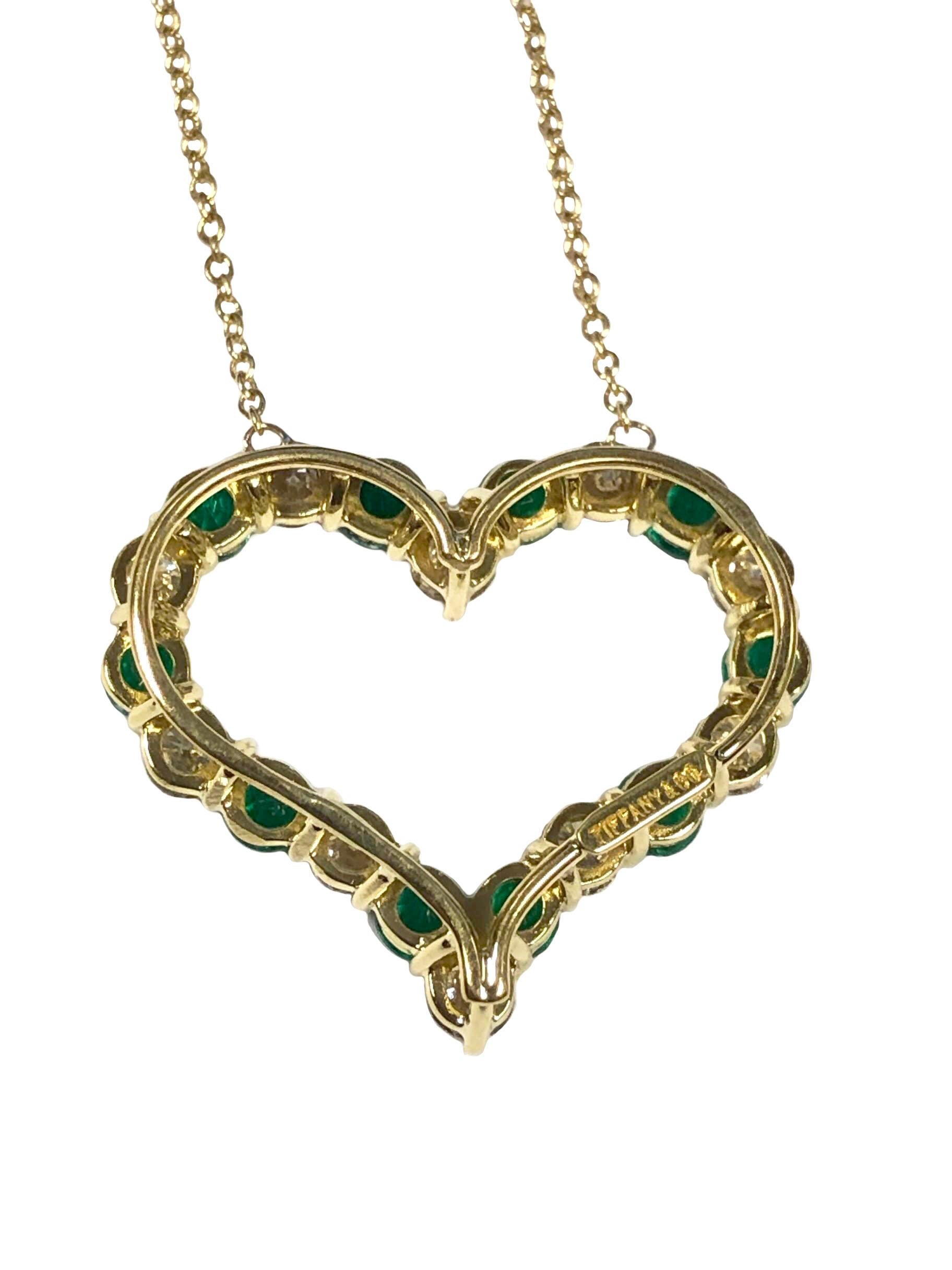 Circa 2000 Tiffany & Company 18K yellow Gold Heart Pendant Necklace, the Heart measures 7/8 inch in length X 1/2 inch wide, set with very fine Bright color Emeralds totaling approximately 1.30 Carats and further set with Round Brilliant cut Diamonds
