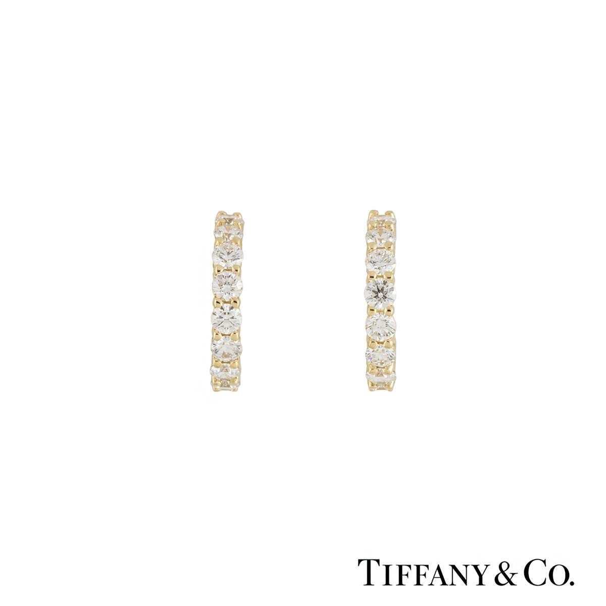A pair of 18k yellow gold diamond hoop earrings by Tiffany & Co. Each hoop has 10 claw set round brilliant cut diamonds totalling 0.60ct, G colour and VS in clarity. The earrings measure 1.2cm in length and have post and alpha back fittings, with a