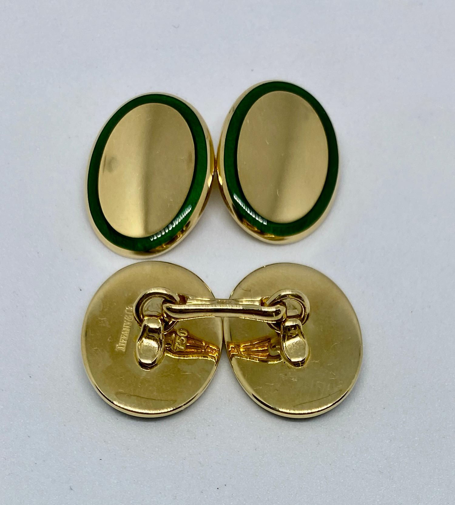 An exceptionally well-made pair of cufflinks in solid, 18K yellow gold featuring green enamel borders. 

The four oval faces each measure 18.4 by 13.9mm, and are attached to their mates with sturdy 
