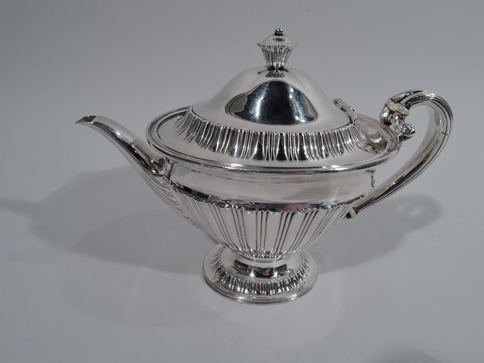 Edwardian classical sterling silver bachelor tea set. Made by Tiffany & Co. in New York. This set comprises 3 pieces: Teapot, creamer, and sugar.

Each: Conical body on raised oval foot. Handles reeded with scrolled and split mount. Covers domed