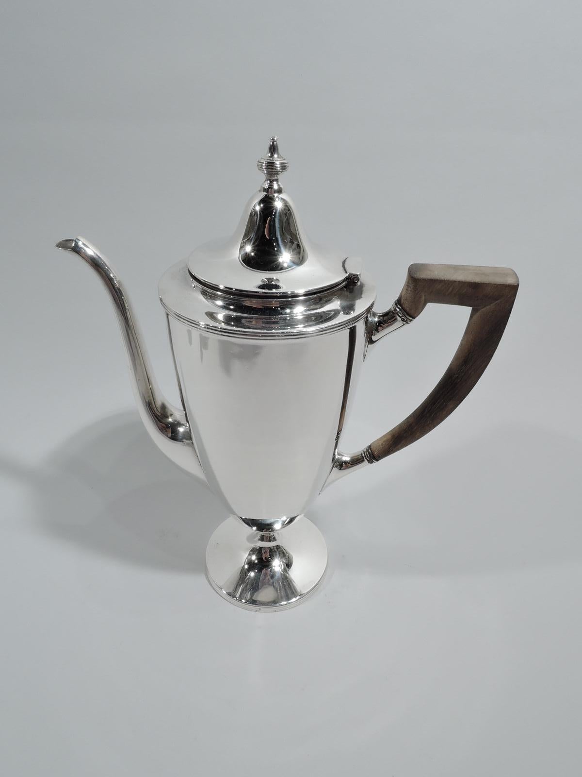 Edwardian classical sterling silver coffee set. Made by Tiffany & Co. in New York, ca 1907. This comprises coffeepot, creamer, and sugar. Coffeepot: Tapering body on raised foot, hinged and domed cover with vasiform finial, vertical s-scroll spout,