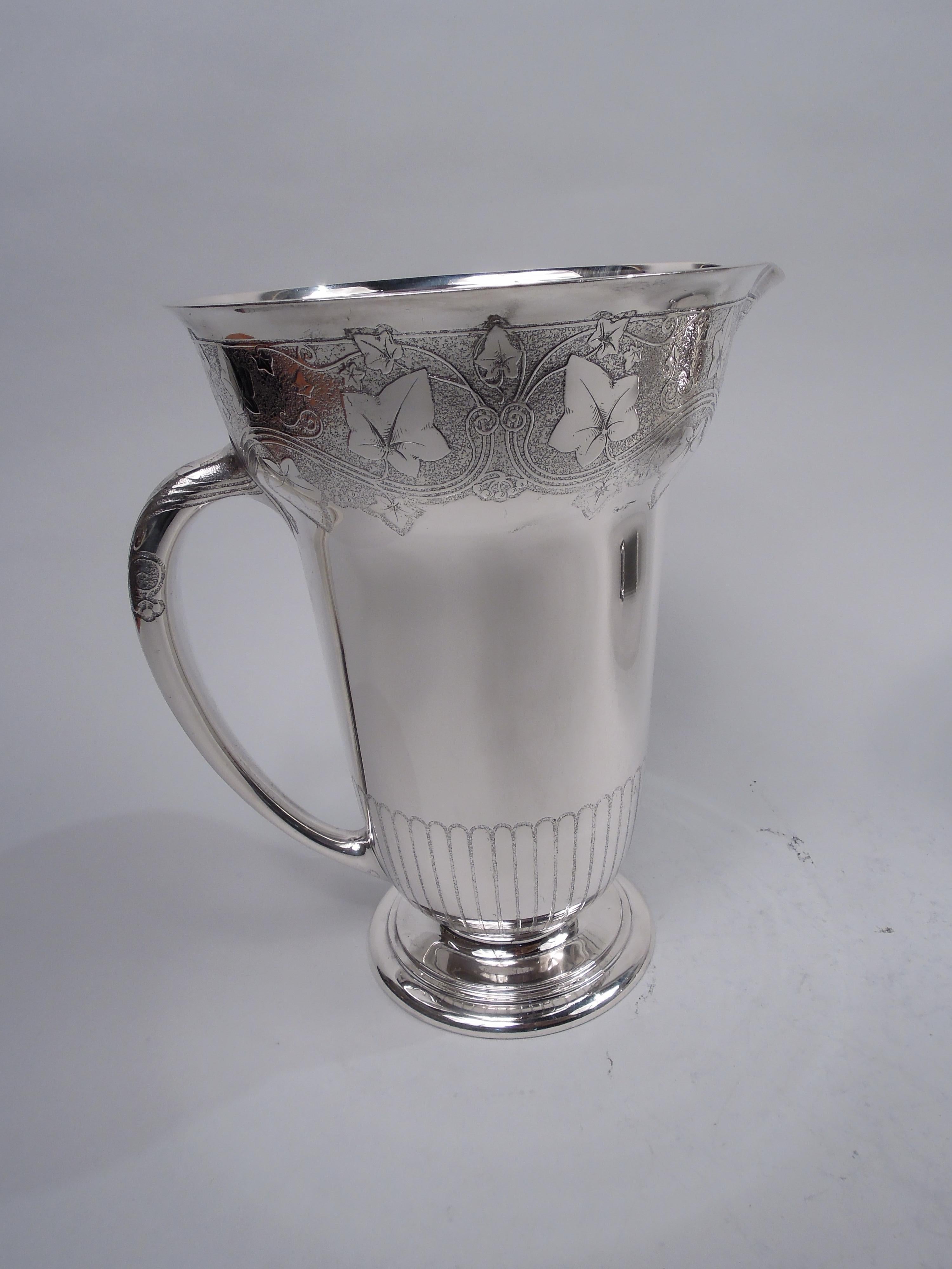 Edwardian Modern Classical sterling silver water pitcher. Made by Tiffany & Co. in New York, ca 1907. Bombe form. Curved and overhanging mouth with lip spout and cylindrical bowl; round and stepped foot and c-scroll handle. Acid-etched ornament:
