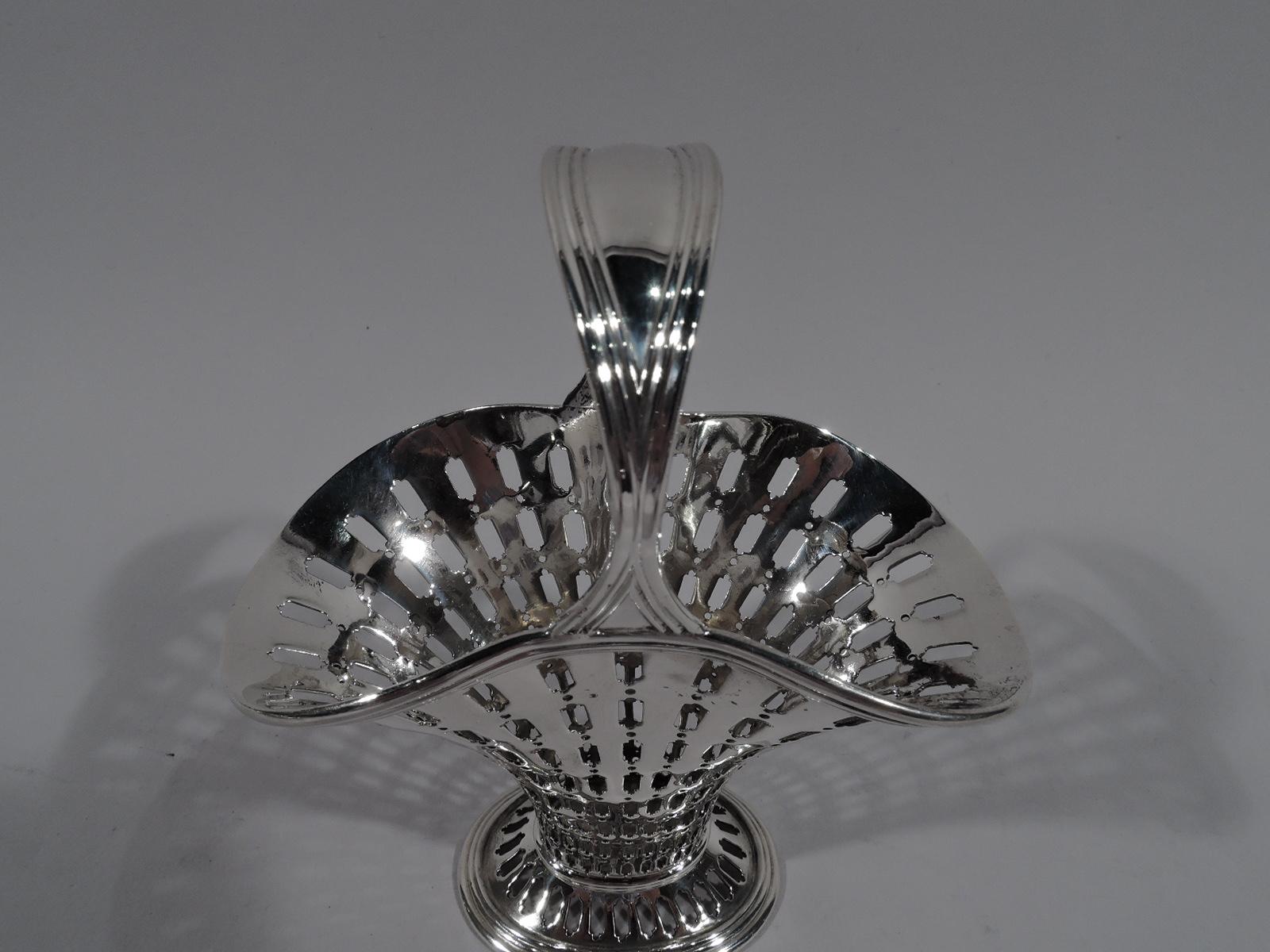 Small Edwardian Modern sterling silver basket. Made by Tiffany & Co. in New York. Tapering and “squashed” ovoid body with flared mouth and spread foot. Reeded and tapering stationary handle. Graduated tubular piercing. Hallmark includes pattern no.