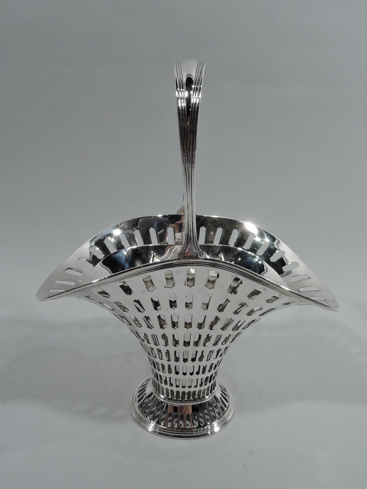 Edwardian Modern sterling silver basket. Made by Tiffany & Co. in New York. Tapering and “squashed” ovoid body with flared mouth and spread foot. Reeded and tapering stationary handle. Graduated tubular piercing. With silver-plated liner. Basket