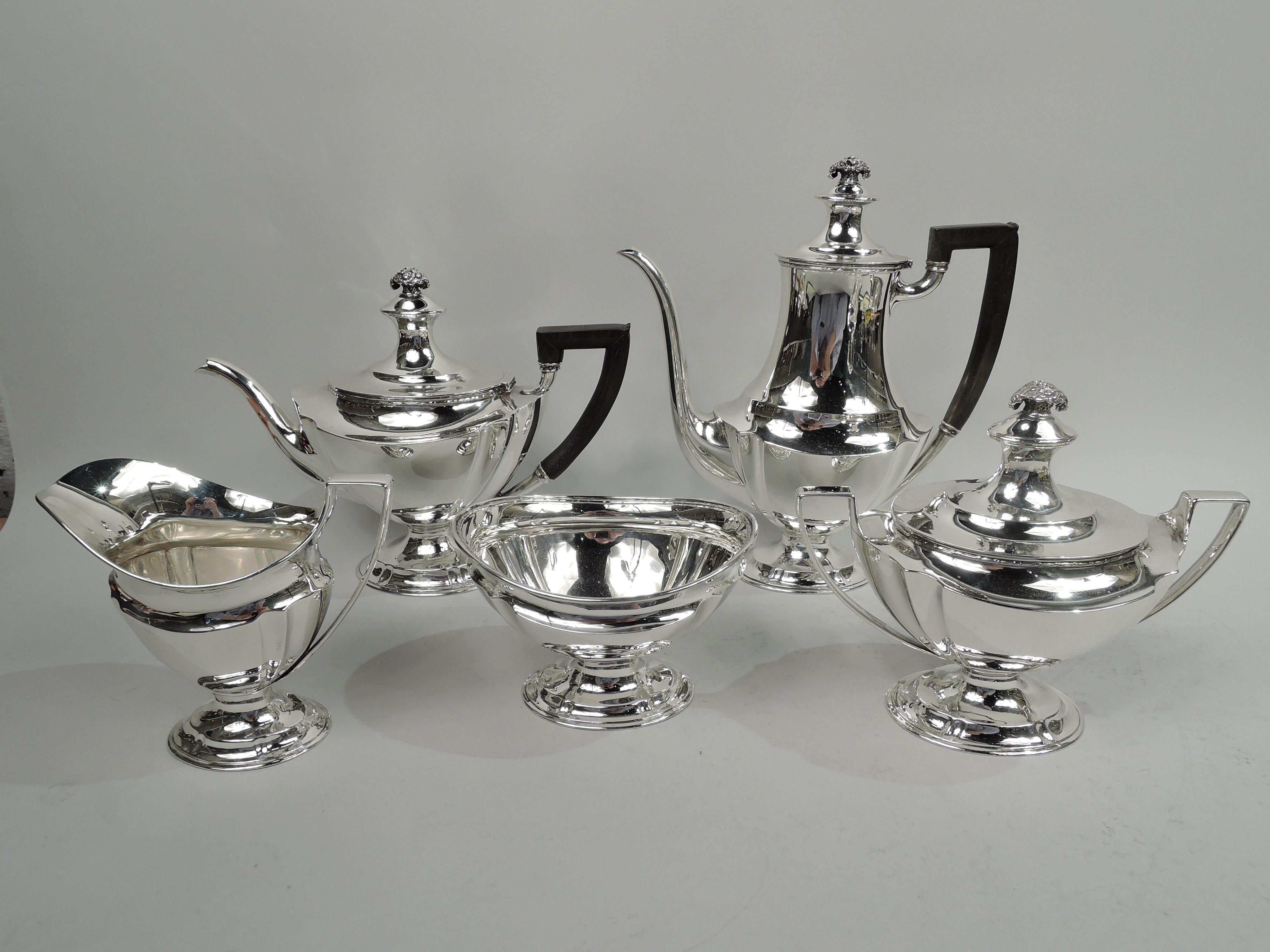 Edwardian Regency sterling silver coffee set. Made by Tiffany & Co. in New York, ca 1910. This set comprises coffeepot, teapot, creamer, sugar, and waste bowl. Tapering and fluted ovoid bodies. Feet domed. Covers double domed with cast flower basket