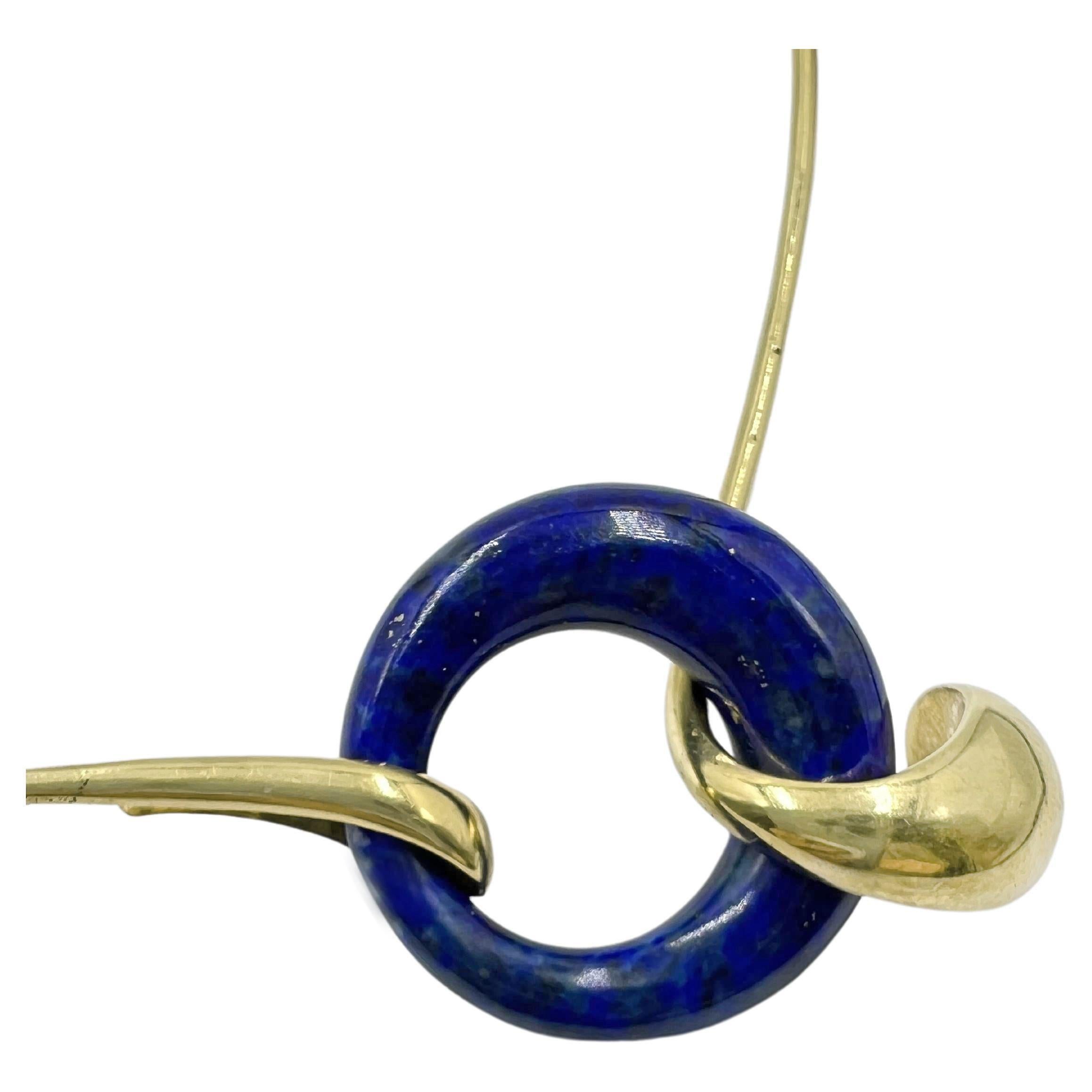 Rare and collectible 1970s design by Elsa Peretti for Tiffany & Co.  18k yellow gold wire collar centering a sculptural lapis lazuli ring measuring 28.45mm diameter.  Flecks of natural calcite and pyrite adorn the rich blue color.  Polished and