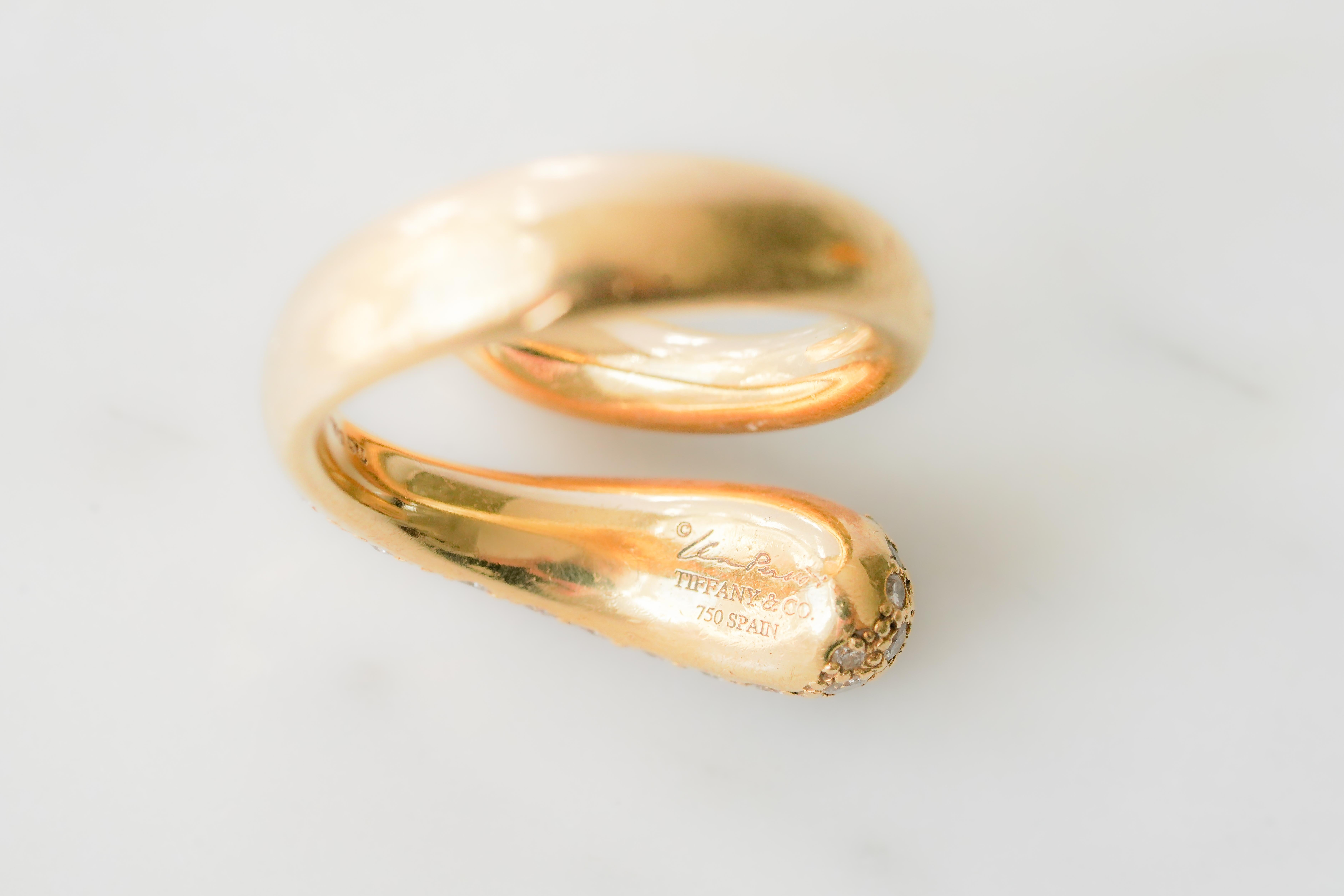 Fluido e libero, questo anello di Elsa Peretti for Tiffany & Co. ha un design raffinato che cattura l'attenzione. L'anello è realizzato in oro giallo 18 carati e vanta un design a goccia attorcigliato parzialmente incastonato con un pavé di