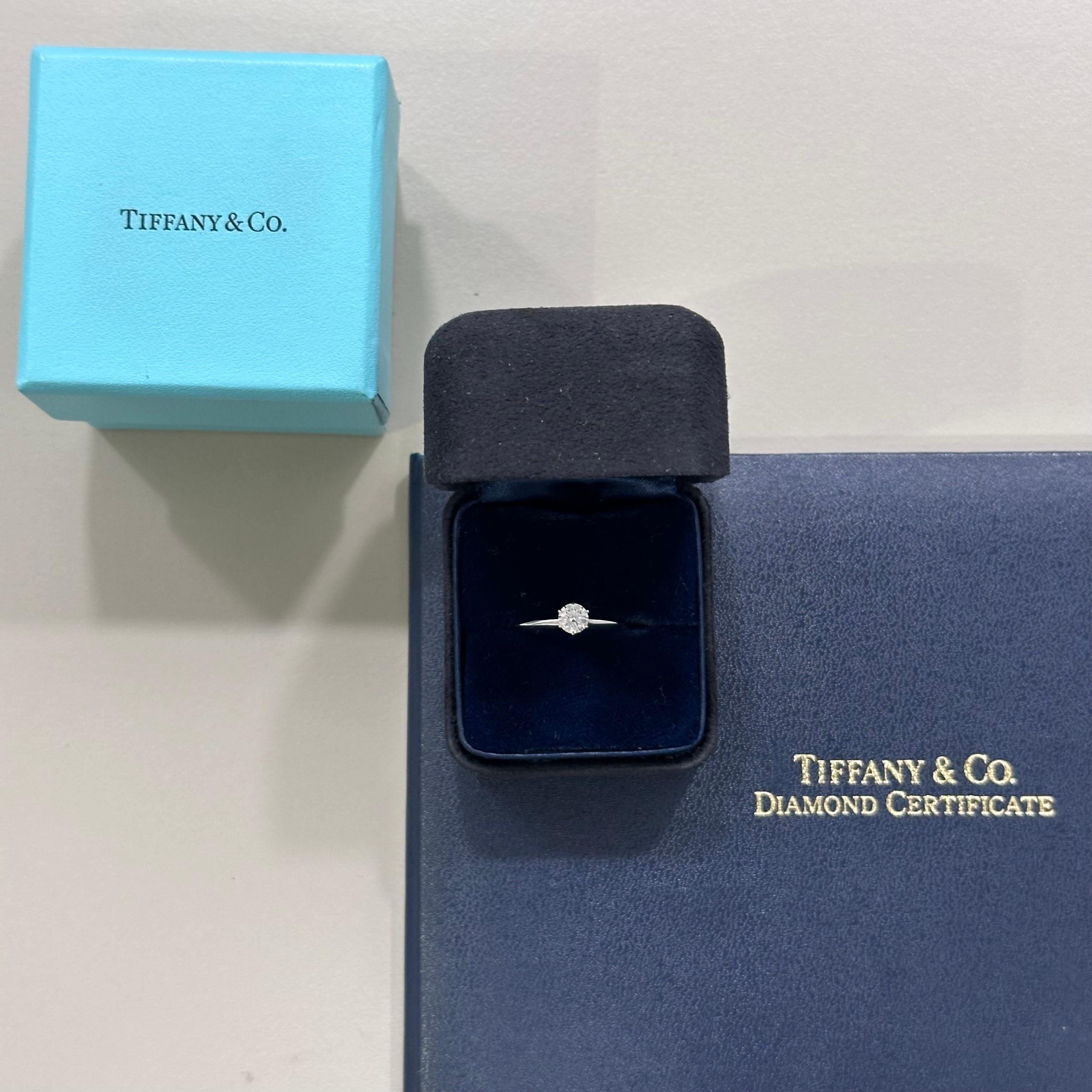 Zeitlose Eleganz mit dem Tiffany-Verlobungsring, einem exquisiten Schmuckstück mit einem natürlichen Diamanten im Brillantschliff von 0,38 Karat, der in einem klassischen Solitär gefasst ist. Dieser aus 950er Platin gefertigte Ring ist ein Beweis