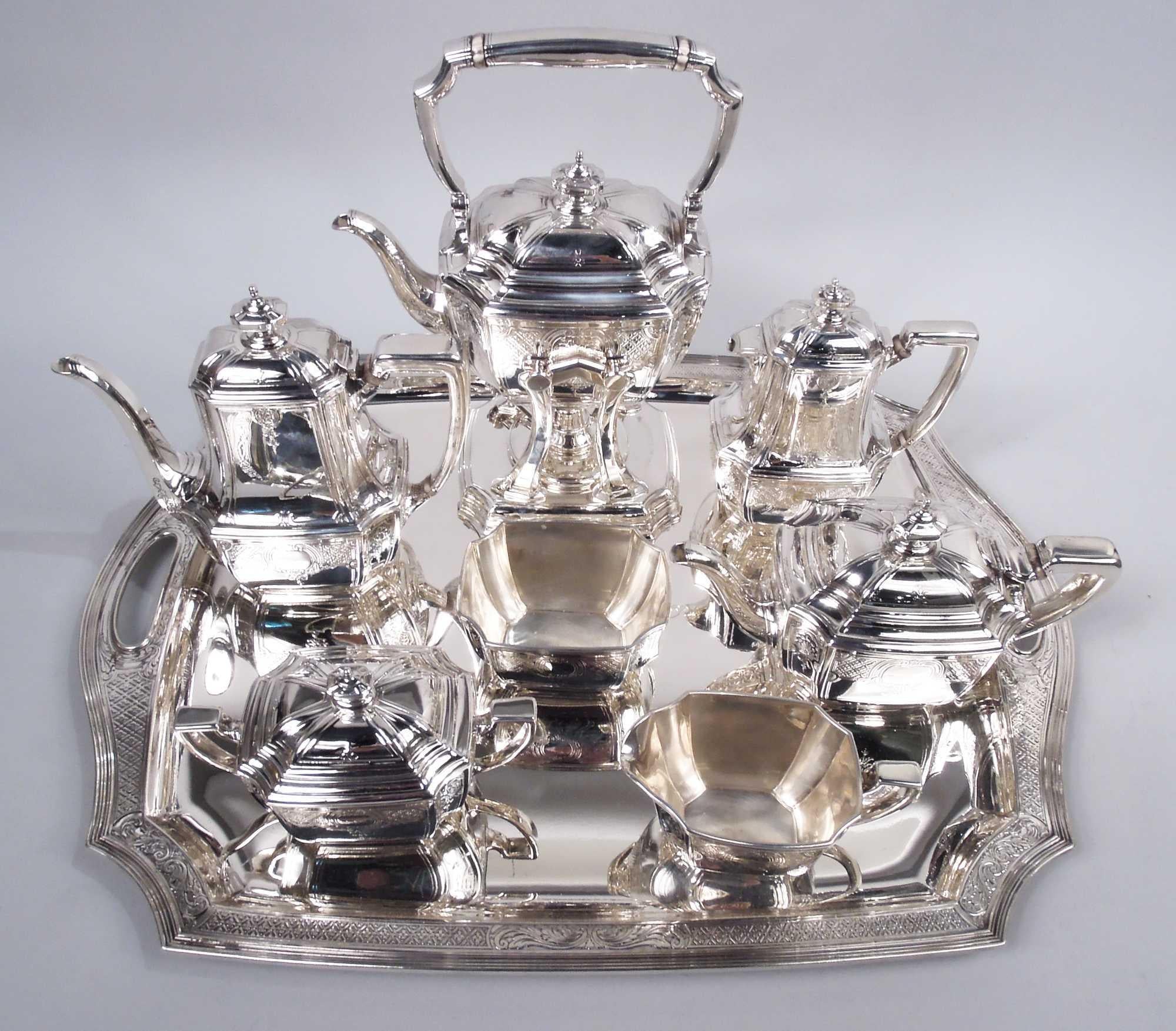 Engraved Hampton sterling silver coffee and tea set. Made by Tiffany & Co. in New York, ca 1920. This set comprises 8 pieces: Hot water kettle on stand, coffeepot, teapot, hot milk pot, creamer, sugar, and waste bowl on tray.

Rectilinear with