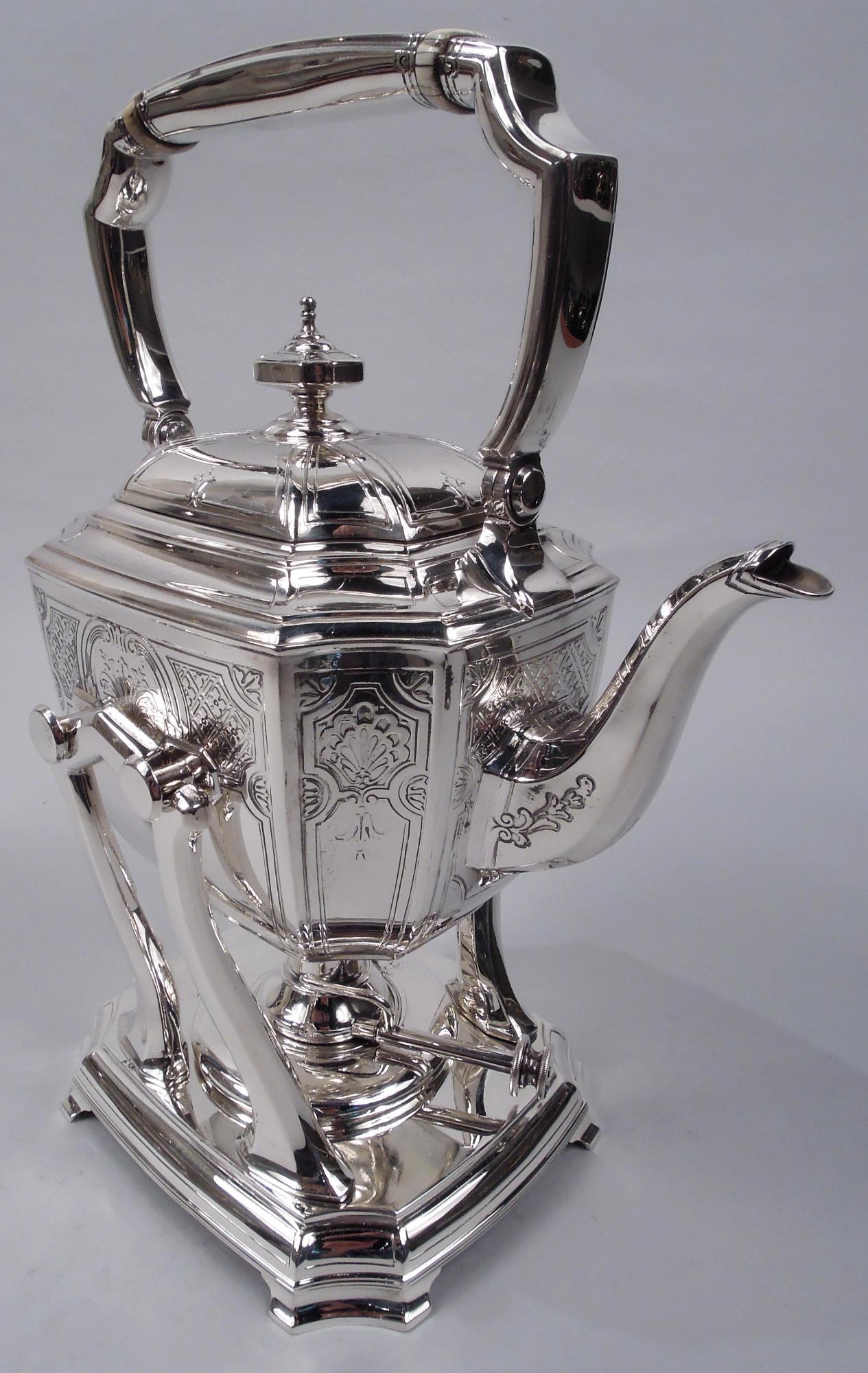 Engraved Hampton sterling silver hot water kettle on stand. Made by Tiffany & Co. in New York, ca 1912. Kettle curved and rectilinear with concave corners faceted s-scroll handle, and swing-mounted handle; cover domed and side-hinged with finial.