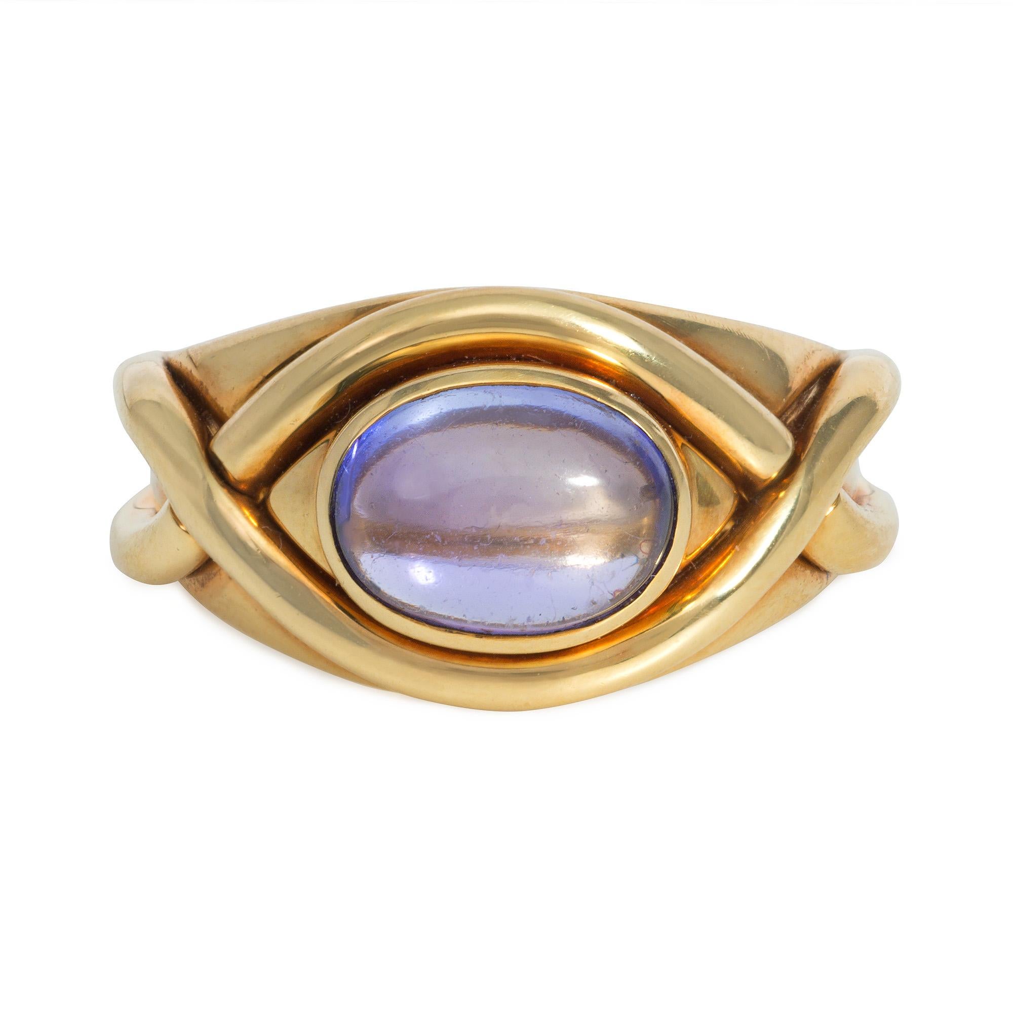A gold and cabochon tanzanite ring decorated with two applied woven gold bands, in 18k.  Tiffany & Co.  Face up dimensions approximately 8mm x 14mm

Tiffany & Co. recognized tanzanite's potential to rival the more expensive sapphire and signed on to