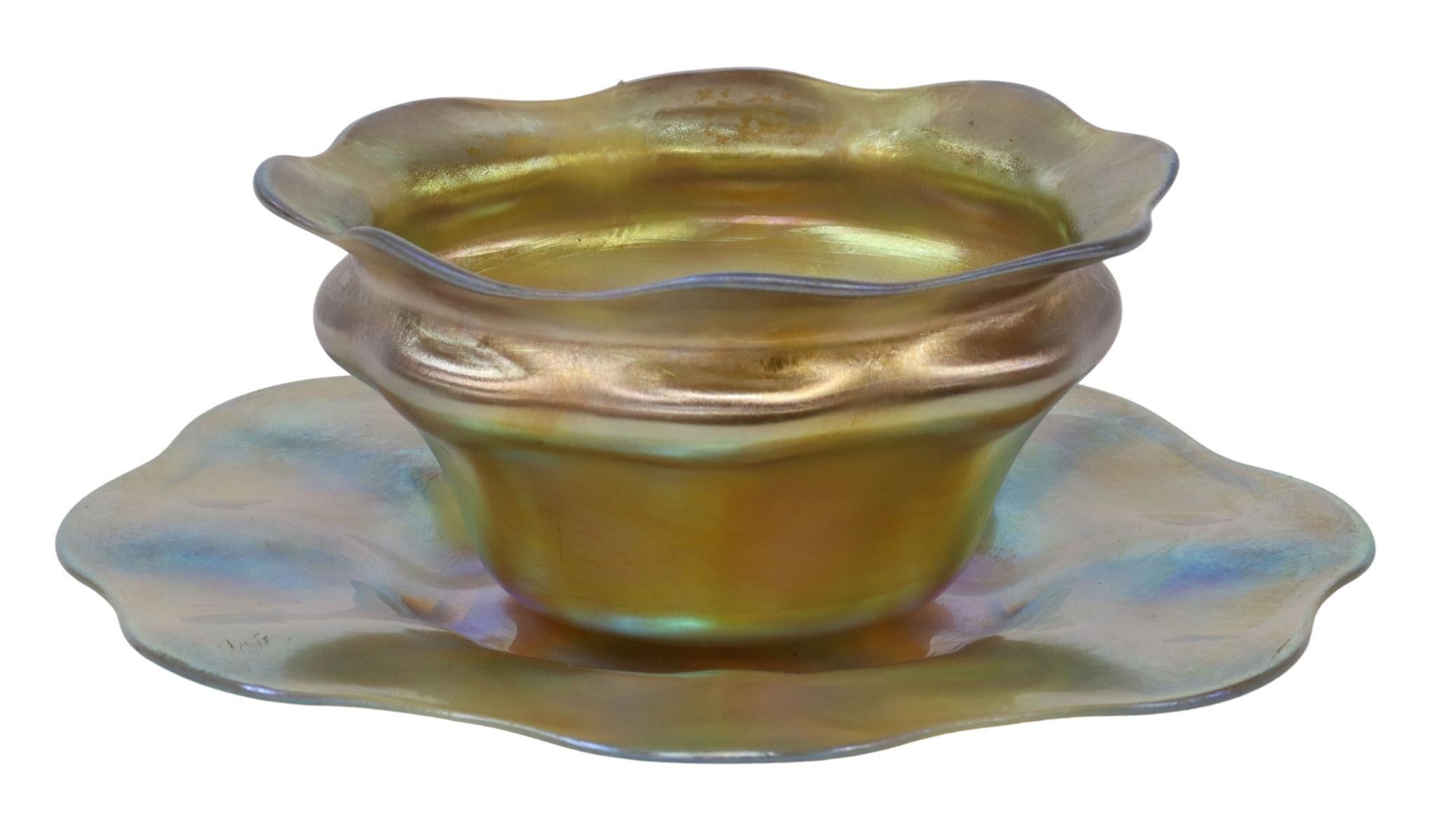 Beautiful favrile art glass bowl and underplate, Louis Comfort Tiffany (New York, 1848-1933), early 20th c., iridescent gold glass, with gently scalloped rim, engraved signature 