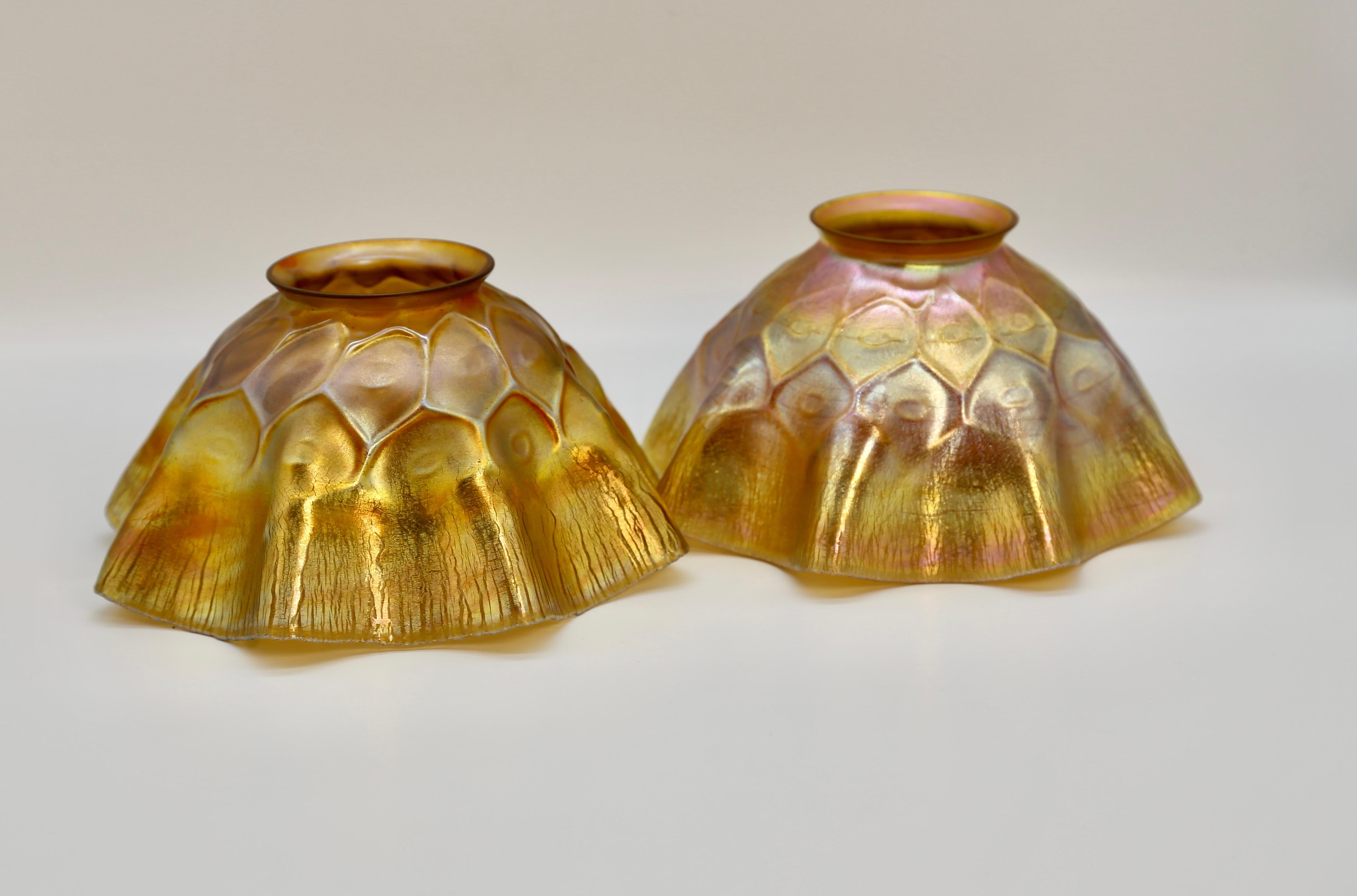 Two premier quality Tiffany Favrile Glass Candle Shades in iridescent gold with a soft honey comb design. Both shades are signed L.C.T. and are in perfect condition. 

Shades measure 4 inches tall and 7 inches wide.

Tiffany founded the Tiffany