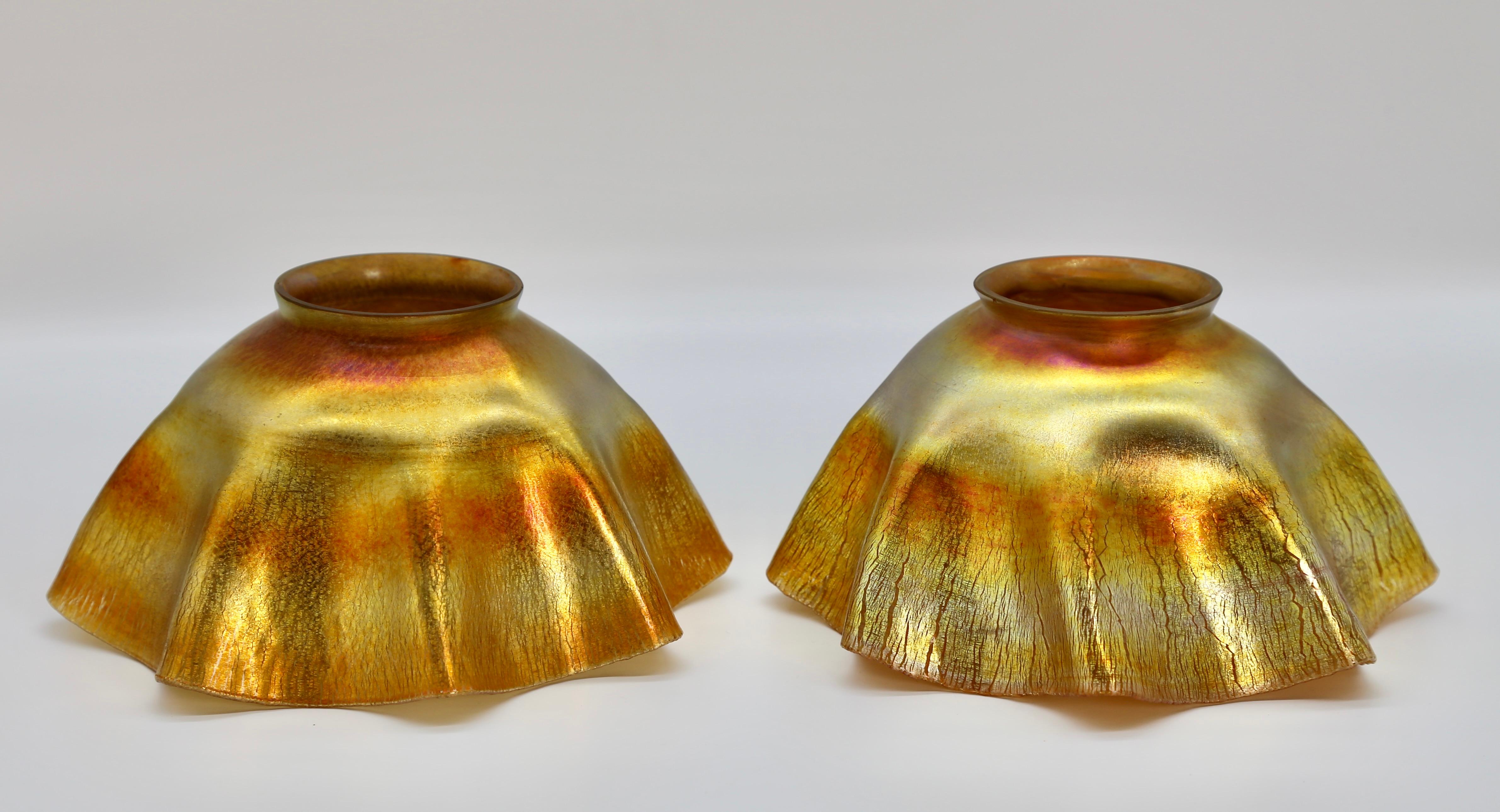 A pair of premier quality Tiffany Favrile Glass Candle Shades in rich iridescent gold fabric fold design. Both shades are signed L.C.T. and are in perfect condition. 

Shades measure 4 inches tall and 7 inches wide.

Tiffany founded the Tiffany