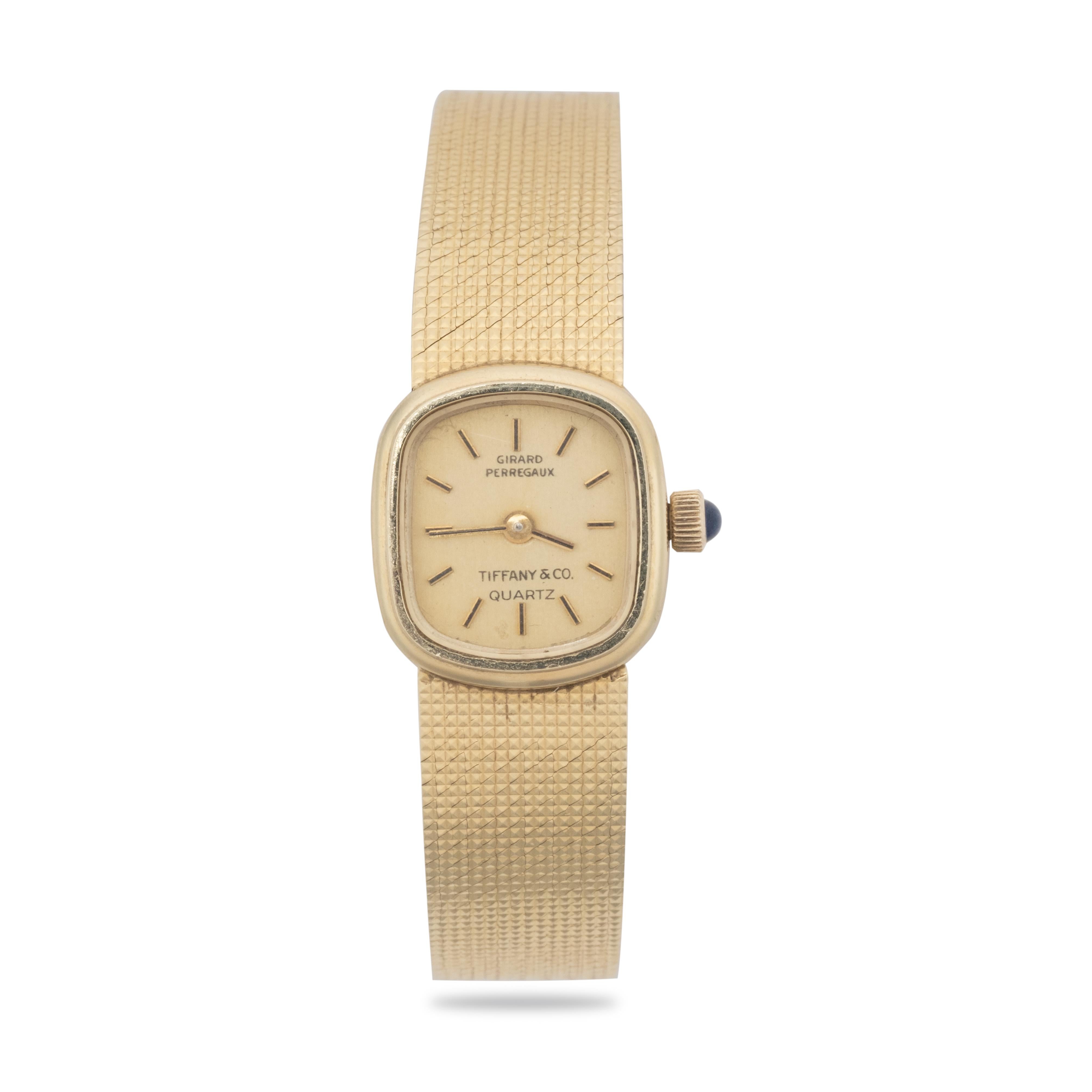 Vintage 14k gold ladies wristwatch made in collaboration of Tiffany & Co. and Girard-Perregaux. Square yellow dial with baton indexes, inscription Tiffany and Co., Girard Perregaux Quartz. The watch has a mesh bracelet with a clasp lock. Hallmark