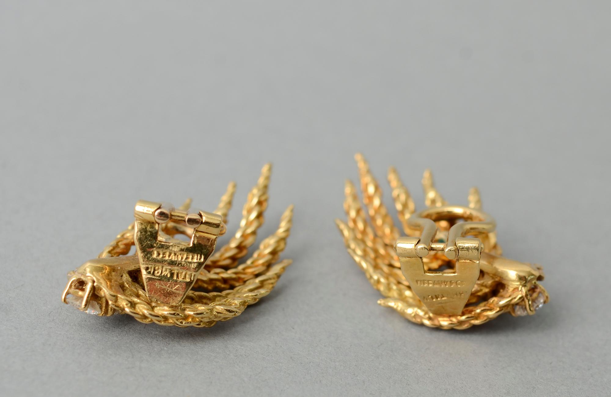 Ohrringe aus 18 Karat Tiffany-Gold in Form von Zweigen oder Flammen. An der Unterseite der Ohrringe befinden sich jeweils drei abgestufte Diamanten mit einem Gesamtkaratgewicht von 0,40 Karat pro Ohrring.
Clip-Rückwände können in Pfosten umgewandelt