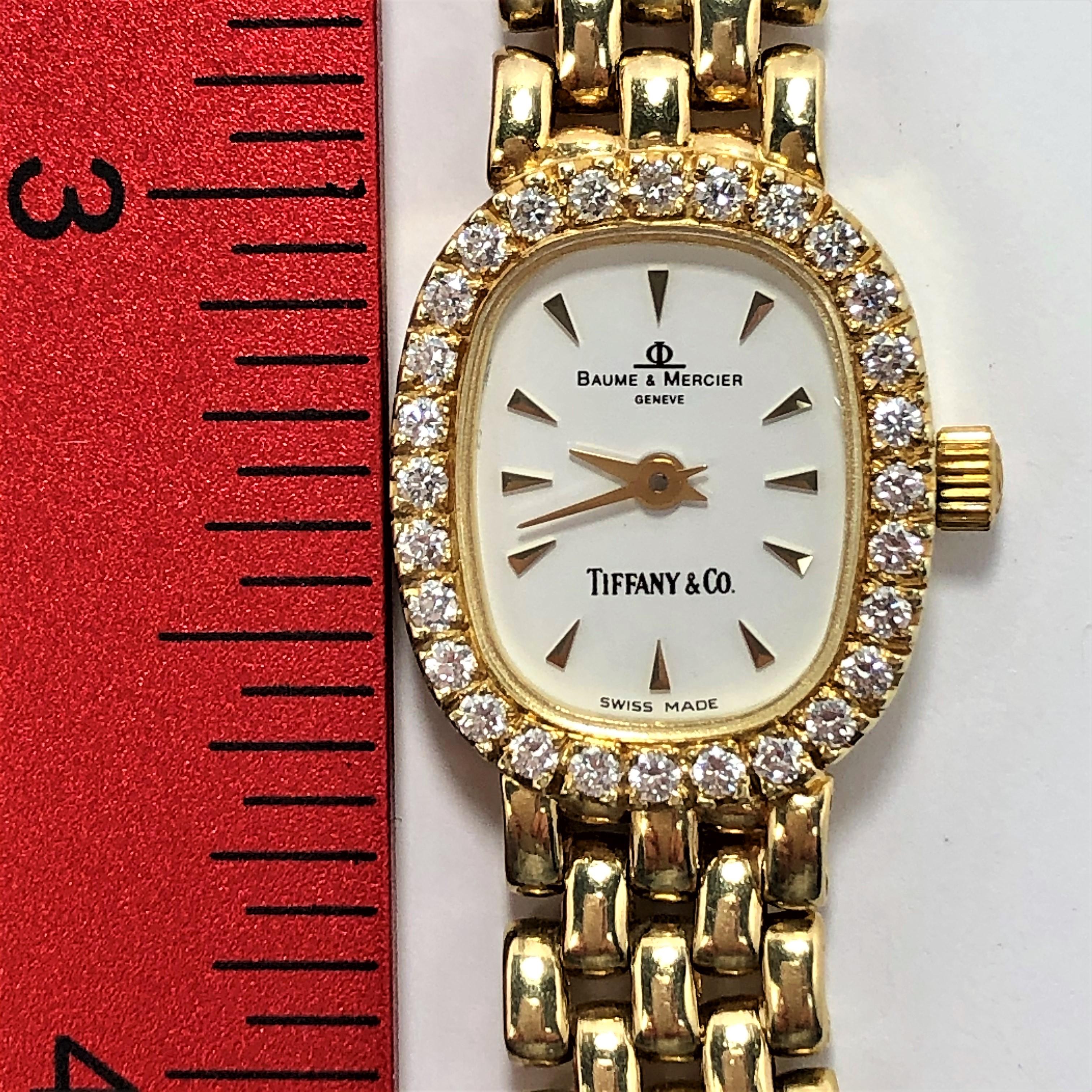Made by Baume & Mercier for Tiffany, this dainty 14K yellow gold 
watch is bezel set with 28 round brilliant cut diamonds weighing
and approximate total of .45CT of G Color and VS1 Clarity. The
integral gold band offers three different settings